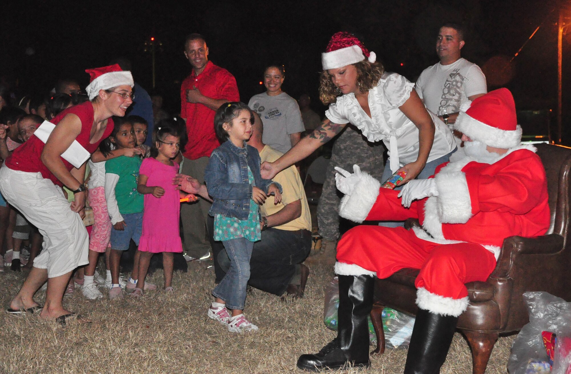 SOTO CANO AIR BASE, Honduras – Santa Claus hands out presents and candy to children from a local orphanage Dec. 1 in front of the base Christmas tree near Building B-202. The children were brought on base for the tree-lighting ceremony. After the tree lighting they sang some Christmas carols, listened to the reading of “A Christmas Story” and had a surprise visit from Santa Claus, who handed out presents and candy to all the children (U.S. Air Force photo/Staff Sgt. Chad Thompson).