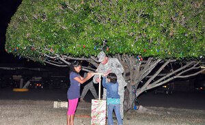SOTO CANO AIR BASE, Honduras -- Army Col. Chris Gehler, Joint Task Force-Bravo commander, and two children from a local orphanage press the plunger and light the base Christmas tree near Building B-202 Dec. 1. More than 40 children from a local orphanage were brought on base for the ceremony. After the tree lighting they sang some Christmas carols, listened to the reading of “A Christmas Story” and had a surprise visit from Santa Claus, who handed out presents and candy to all the children (U.S. Air Force photo/Staff Sgt. Chad Thompson).