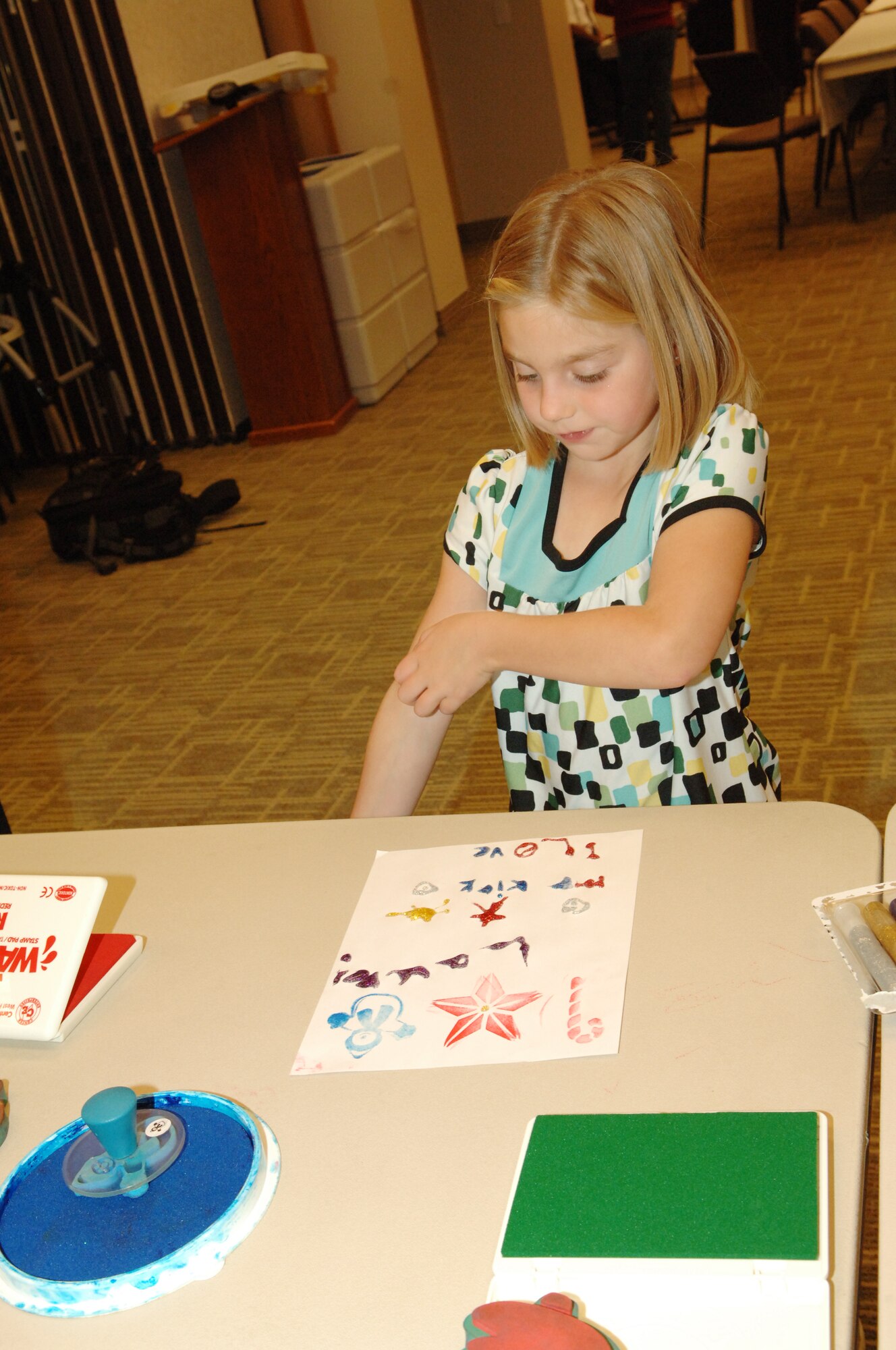 BUCKLEY AIR FORCE BASE, Colo. -- Lauren Clarkson makes a card for her father during the Deployed Spouses Family Dinner at the Chapel Annex Dec. 4. (U.S. Air Force photo by Tech. Sgt. Shirley Henderson)
