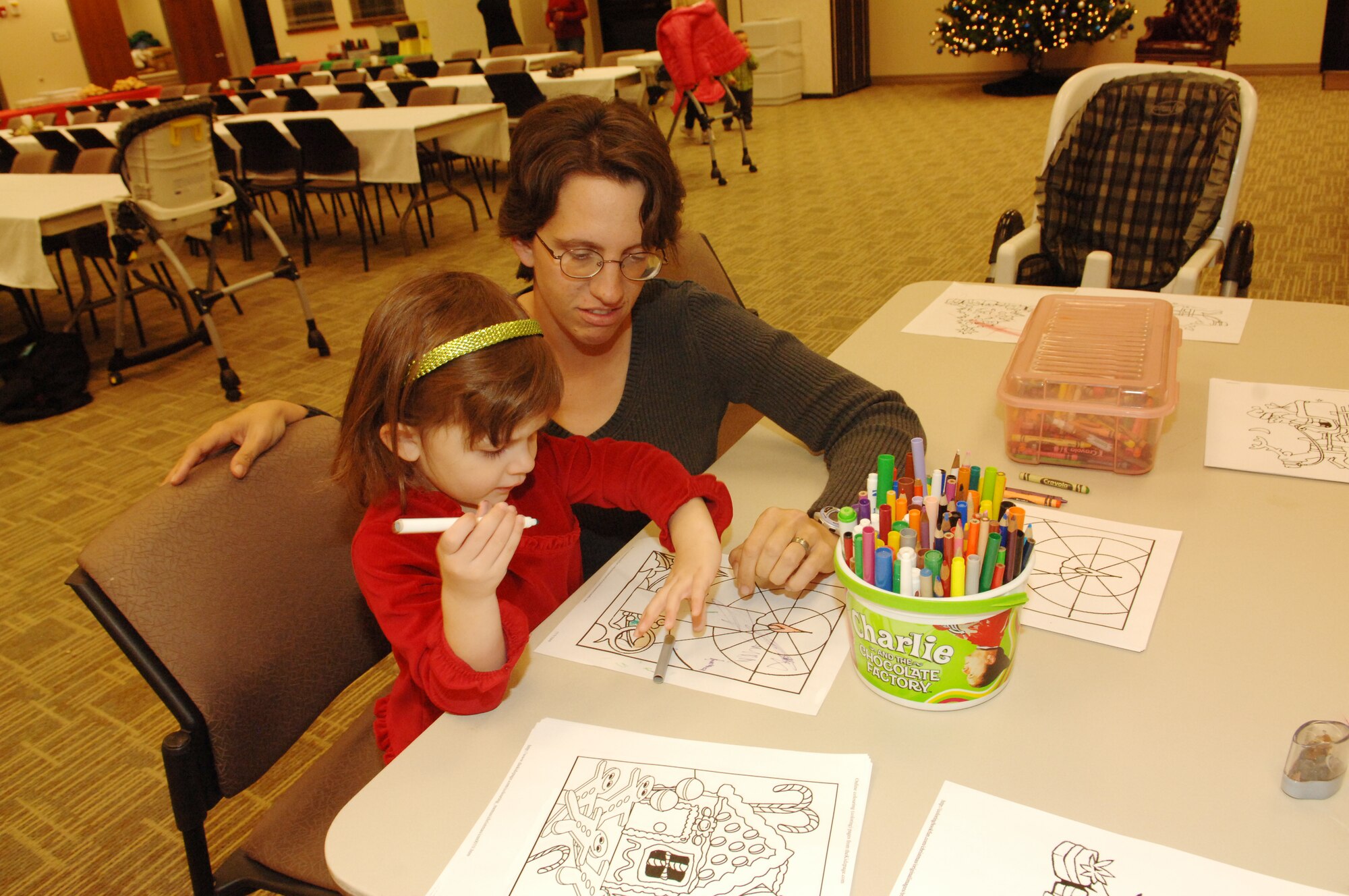 BUCKLEY AIR FORCE BASE, Colo. -- Desiree Bradley helps her daughter Jessica color during the Deployed Spouses Family Dinner at the Chapel Annex Dec. 4. (U. S. Air Force photo by Tech. Sgt. Shirley Henderson)