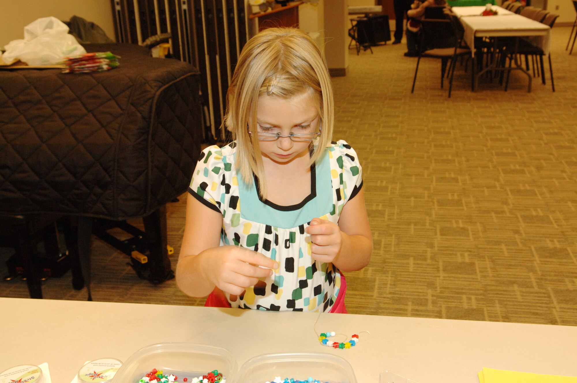 BUCKLEY AIR FORCE BASE, Colo. -- Kirah Clarkson makes a necklace during the Deployed Family Spouses Dinner at the Chapel Annex Dec. 4. (U. S. Air Force photo by Tech. Sgt. Shirley Henderson)