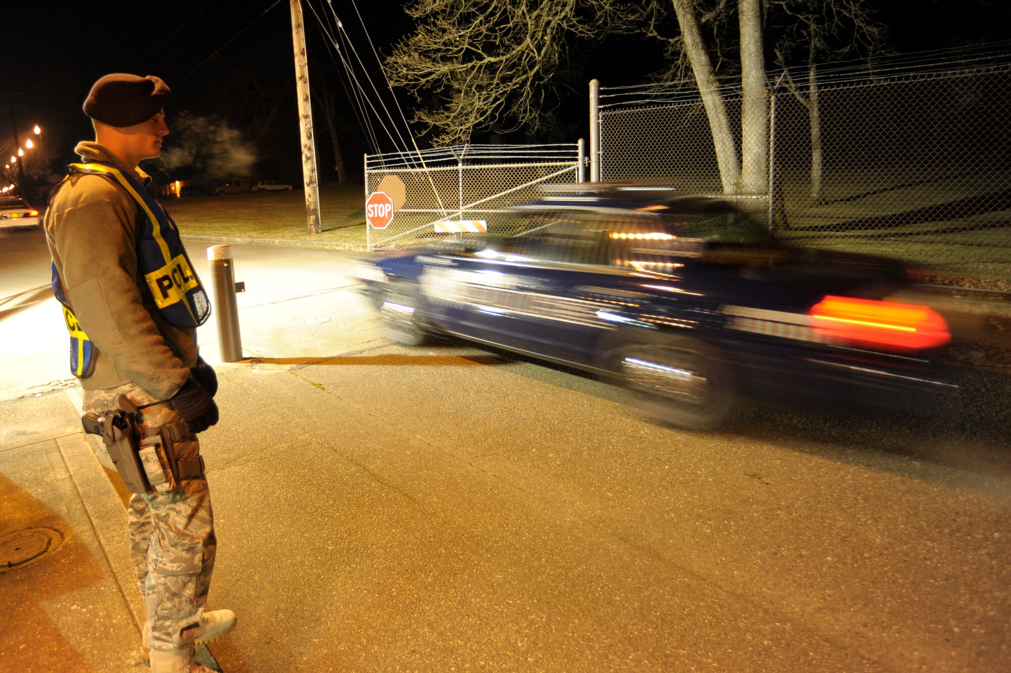 A 62nd Security Forces Squadron Airman mans the McChord north gate where approximately 2,000 emergency services vehicles from throughout the U.S. and Canada are staging their vehicles to depart McChord Dec. 8 in a procession to the Tacoma Dome Memorial Service honoring four fallen Lakewood, Wash., Police Officers. (U.S. Air Force photo/Abner Guzman)