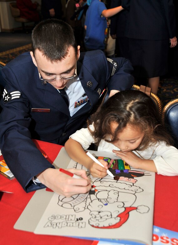 VANDENBERG AIR FORCE BASE, Calif. --  Senior Airman Andrew Pluim, from the 30th  Security Forces Squadron, and Korina Jimenez, from  Santa Ynez, Calif., color a picture of Santa Claus during Operation Kids Christmas here Saturday, Dec. 5, 2009. Coloring books were left on the table for every child to have. (U.S. Air Force photo/Senior Airman Stephanie Longoria)




















