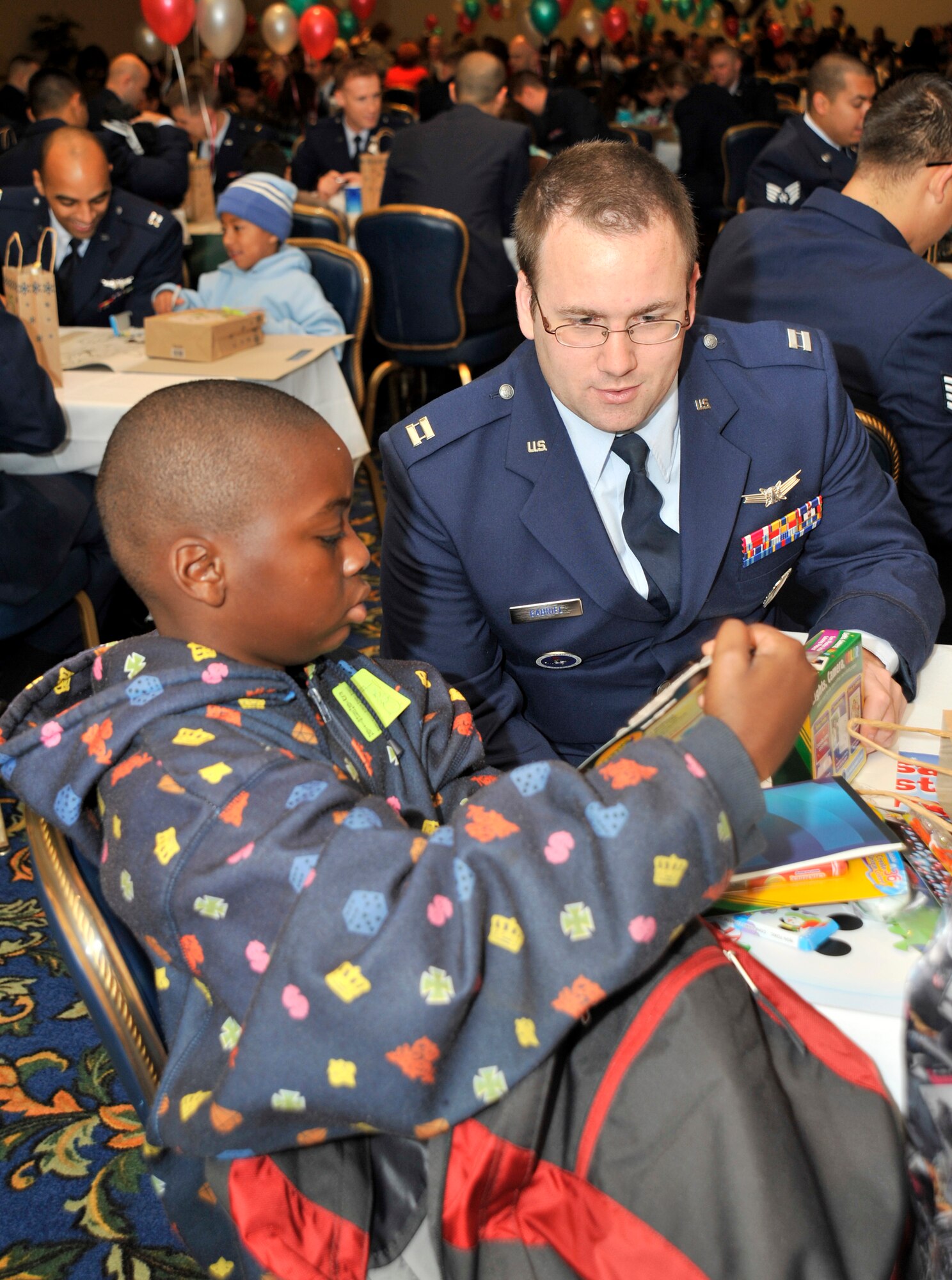 VANDENBERG AIR FORCE BASE, Calif. -- As children arrived at the Pacific Coast Club here to celebrate Operation Kids Christmas, they were all given a backpack with several school supplies and coloring books. Capt. Christian Gabriel, who works with 392nd Training Squadron, and Keyna Purrett ,from Los Angeles, Calif., go through the backpack while waiting for the event to start.  (U.S. Air Force photo/Senior Airman Stephanie Longoria)









