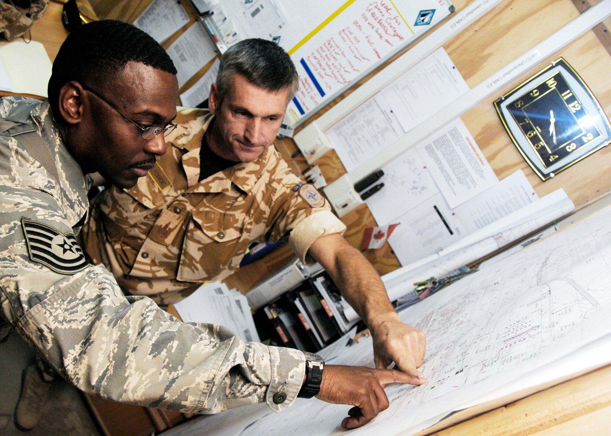 Tech. Sgt. Anthony Moore and British Warrant Officer Neil Baum monitor control construction and facility utilization inside explosives clear zones here Dec. 3, 2009, at Kandahar Airfield, Afghanistan. Sergeant Moore is a weapons safety manager for the 451st Safety Office from Langley Air Force Base, Va. (U.S. Air Force photo/Senior Airman Timothy Taylor)