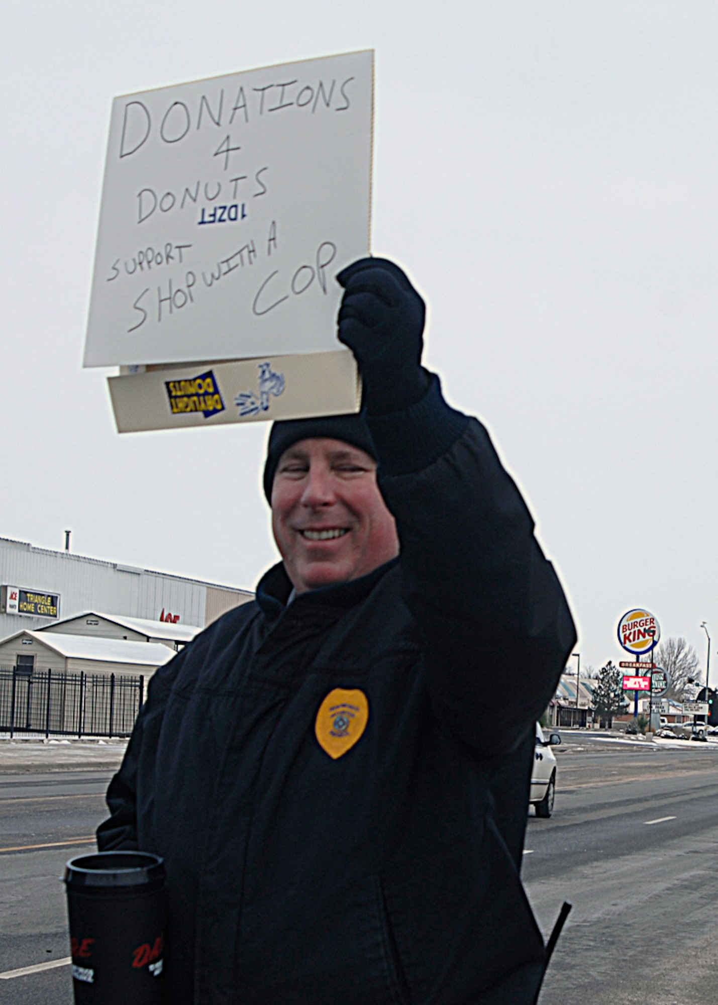 CANNON AIR FORCE BASE, N.M. -- Rich Jones, a retired NCO who was assigned to  the security forces squadron here, solicits donation during the Dollars 4 Donuts program Dec. 4 in Clovis. Mr. Jones, who continues to work at Cannon with the 27th Special Operations Security Forces Squadron, volunteered for the fundraiser that supports the Shop with a Cop program aimed at brightening the holidays for needy children. On Dec. 21 Clovis police and Cannon security forces personnel will take local area children shopping for $100 worth presents for the children. (U.S. Air Force photo by Greg Allen) 