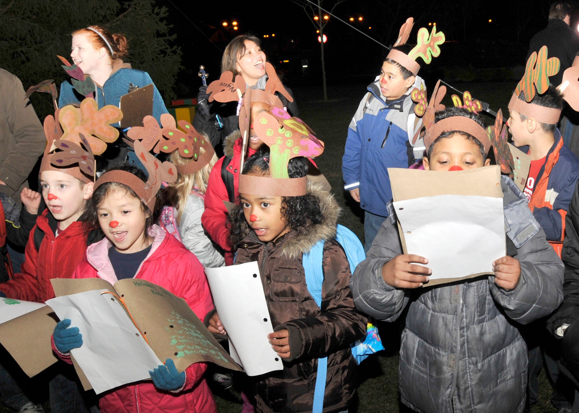 Children enrolled in RAF Lakenheath’s youth program sing Christmas carols at the annual Christmas tree lighting ceremony Dec. 4. The event presided by 48th Fighter Wing Commander Col. Jay Silveria, kicked off the holiday season for Lakenheath.  (U.S. Air Force photo Airman 1st Class Eboni Knox)