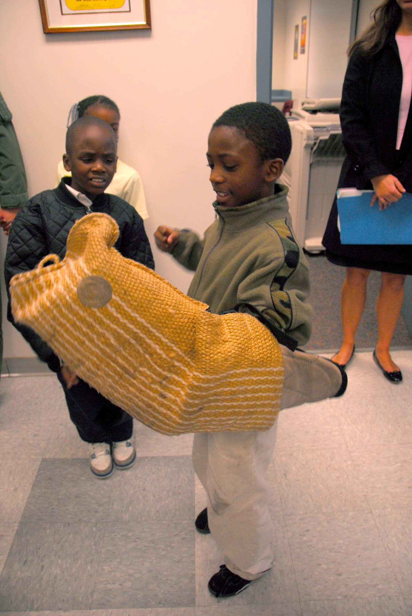 Tyonne Broughton tries on a padded arm protector used to train military working dogs while Ziquan Watson, left, watches before a canine demonstration given by the 437th Security Forces Squadron here Dec. 4. The tour was hosted by the Airman Leadership School and is part of an on going community service project that brings awareness to the opportunities that the Air Force has to offer. Both boys are third grade students from Memminger Elementary School in Charleston. (U.S. Air Force photo/Lauren Laidlaw) 