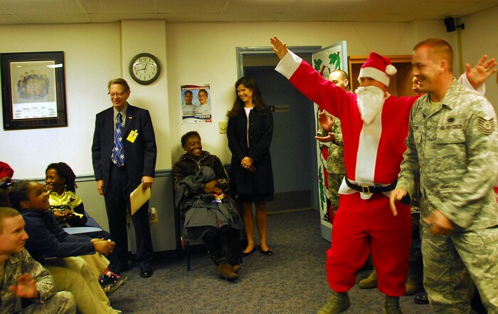 Tech. Sgt. Brandon Hutchins, right, introduces a special guest at the Airman Leadership School here to Memminger Elementary School students Dec. 4. Santa Claus came to visit the group of third grade students, their teachers and members of Team Charleston during a holiday party held at the school at the close of the students' tour of Charleston AFB where they participated in a holiday gift raffle. Sergeant Hutchins is an ALS instructor. (U.S. Air Force photo/Staff Sgt. Daniel Bowles)
