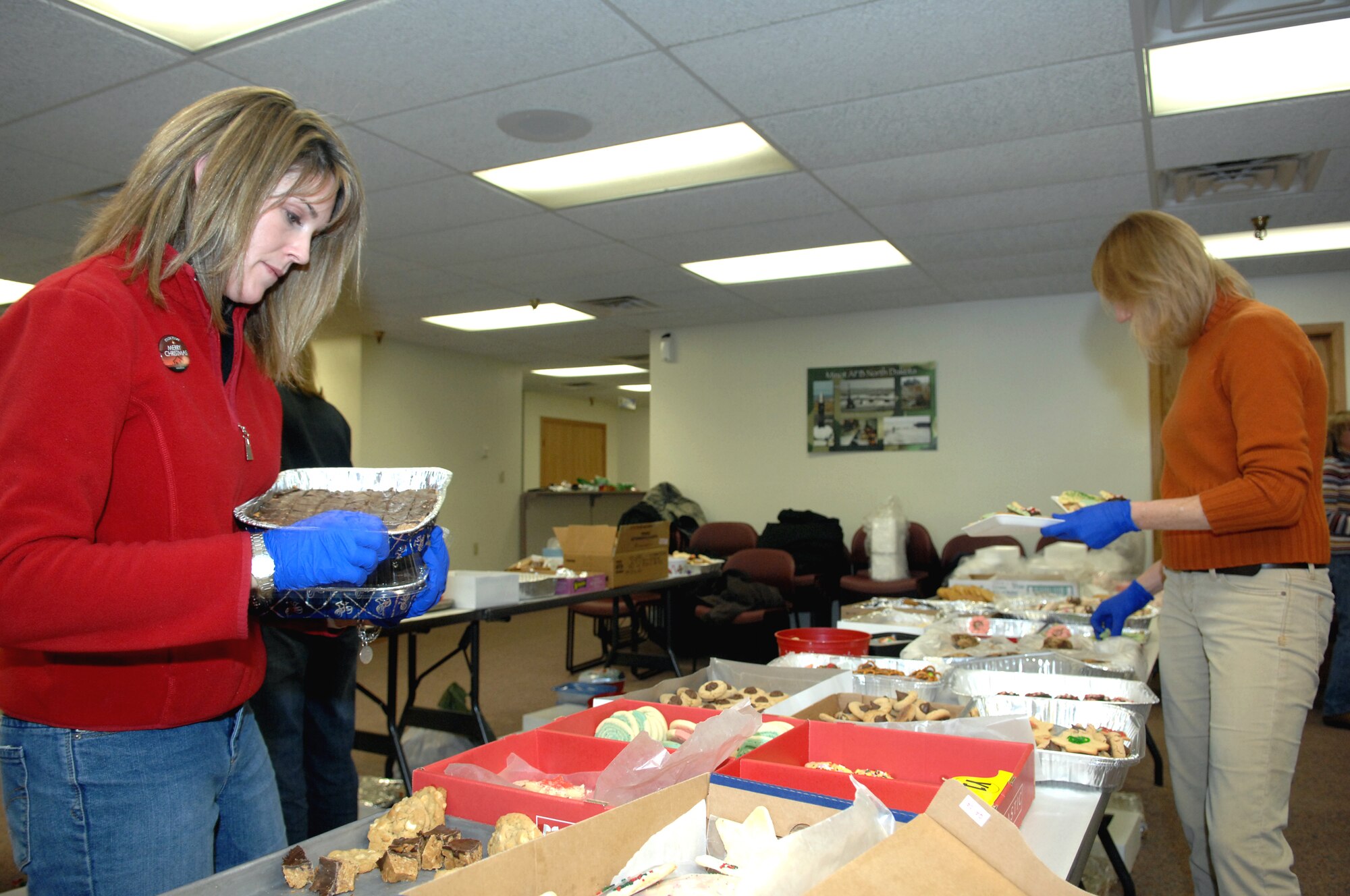 MINOT AIR FORCE BASE, N.D. -- Rebecca Sasseville, wife of Lt. Col. Andrew Sasseville, 91st Security Forces Group deputy commander, and Jolene Tolbert, wife of Col. Julian Tolbert, 5th Bomb Wing vice commander, prepare plates of holiday cookies for Airmen living in the dormitories here Dec. 3. The holiday cookie drive for Minot Airmen is a yearly event engineered to reach out to young Airmen who live in the dorms. Members from the base, local community, and neighboring states provided the cookies as a way to spread holiday cheer. (U.S. Air Force photo by Senior Airman Michael Veloz)