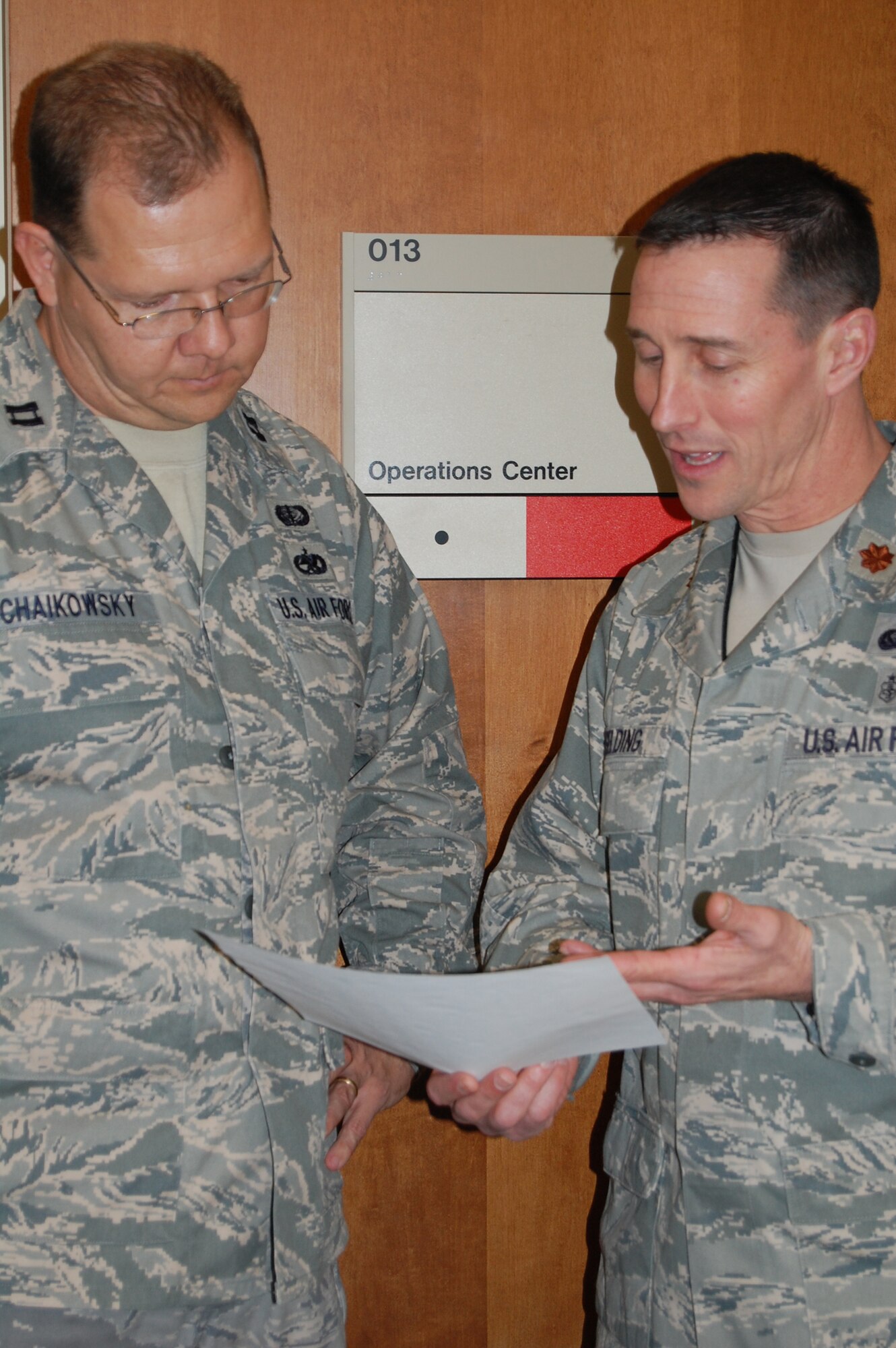 Maj. Scott Uselding (right) discusses an inbound transfer with Capt. William Chaikowsky outside the Air Force Mortuary Affairs Operation Center's Command, Control and Communication section. Capt. Chaikowsky is a Reservist with the 514th Airlift Wing in New Jersey and Maj. Uselding is a Reservist with the 934th Airlift Wing in Minnesota. Both are currently deployed to Dover Air Force Base, Del. 
