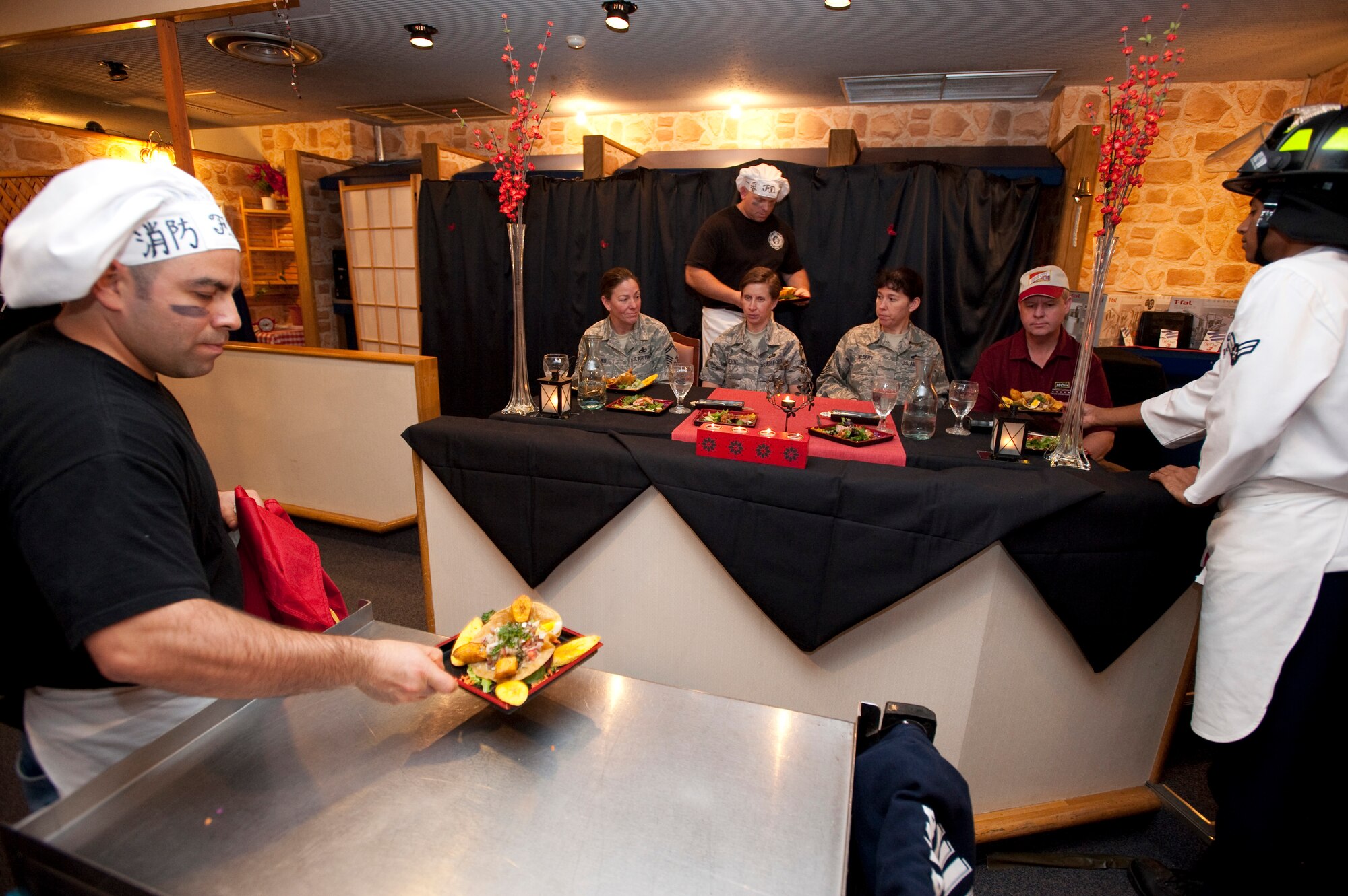 MISAWA AIR BASE, Japan -- Team Diversity serves their main course to the judges at the Grissom Dining Facility Iron Chef Competition Dec. 4. Team Diversity served a two-course meal with a Spanish theme. (U.S. Air Force photo/Staff Sgt. Samuel Morse)