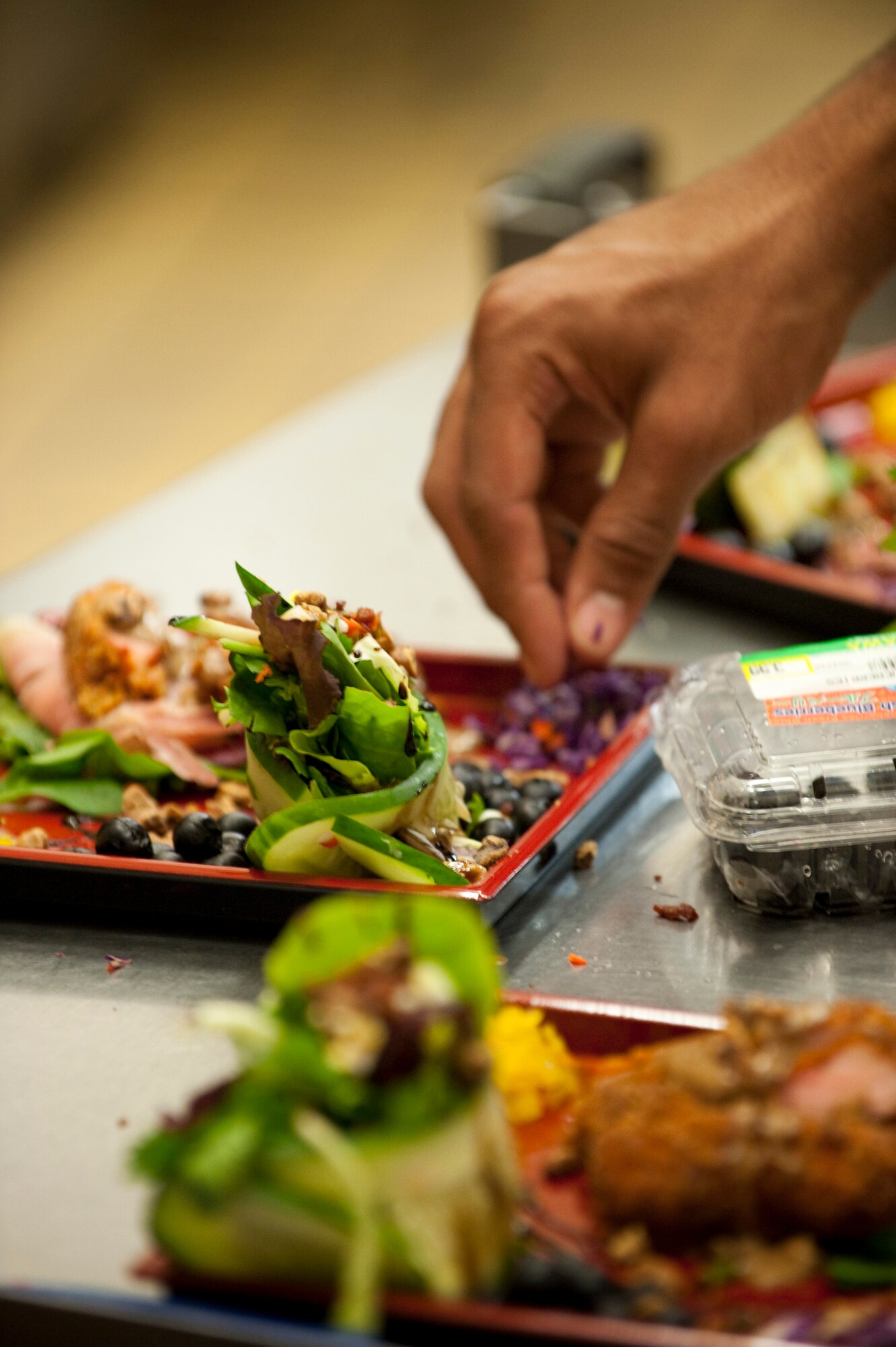 MISAWA AIR BASE, Japan -- Airman 1st Class Sydney Sullivan, 35th Force Support Squadron food service journeyman and sous-chef for Team Diversity, garnishes Team Diversity's appetizer during the Grissom Dining Facility's Iron Chef Competition Dec. 4. The competition judges praised the team for the detail that went into the presentation. (U.S. Air Force photo/Staff Sgt. Samuel Morse)