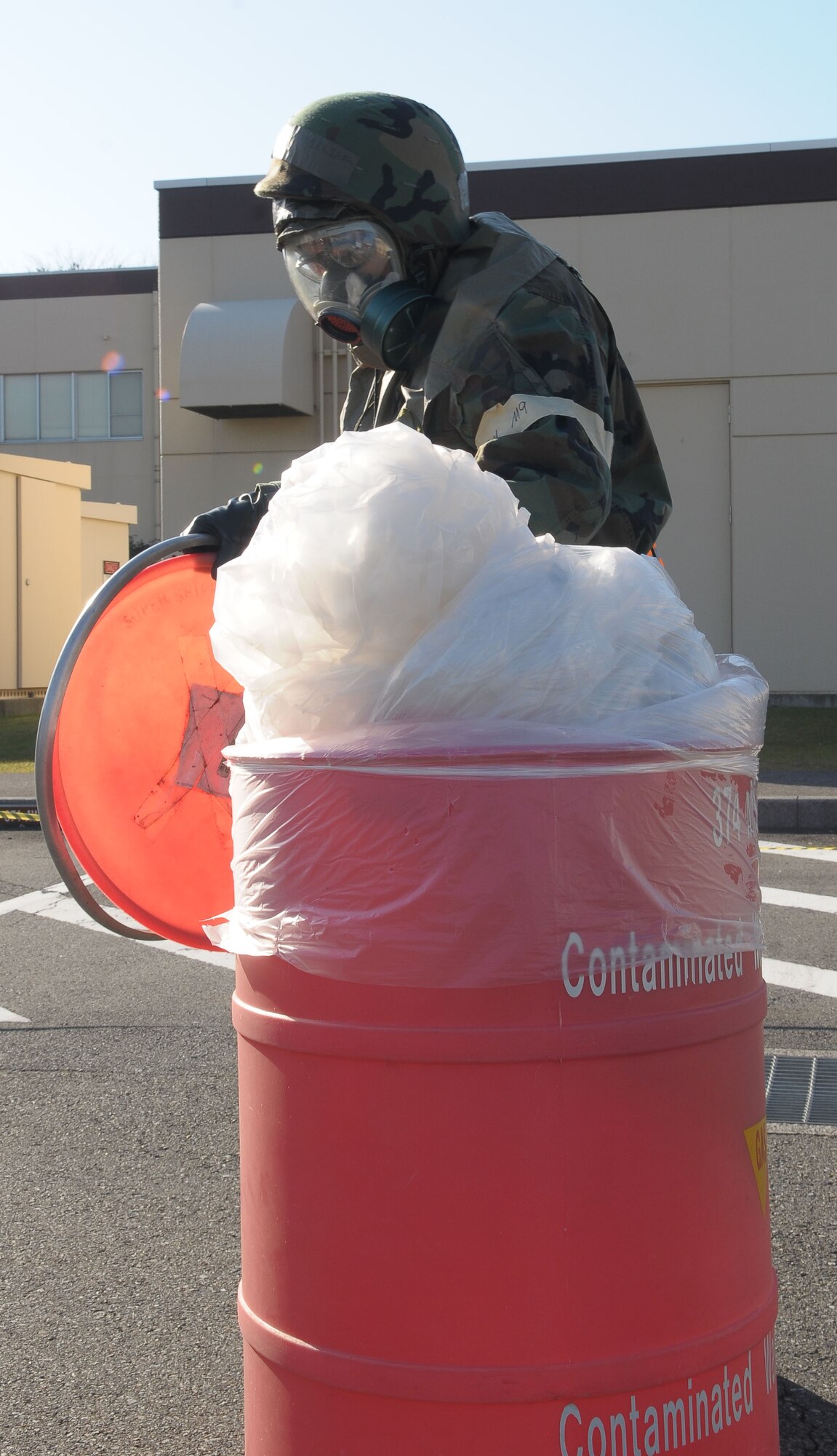 YOKOTA AIR BASE, Japan -- Staff Sgt. Willie Williams, 374th Airlift Wing, disposes of a simulated contaminated vehicle cover Dec. 8 during an operational readiness inspection conducted by the Pacific Air Forces Inspector General. (U.S. Air Force photo/Airman 1st Class Sean Martin)