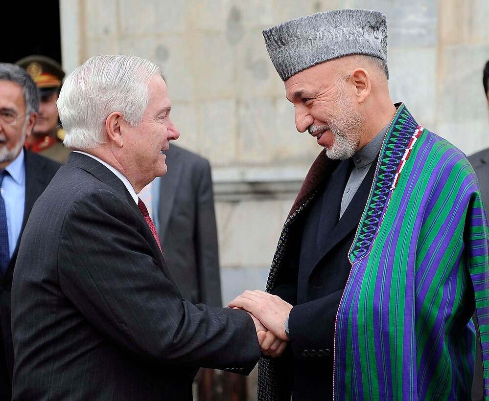 Afghan President Hamid Karzai, right, greets U.S. Defense Secretary Robert M. Gates, left, at the presidential palace in Kabul, Dec. 8, 2009. Gates is on his first trip to Southwest Asia following President Barack Obama's decision to send an additional 30,000 troops to Afghanistan.