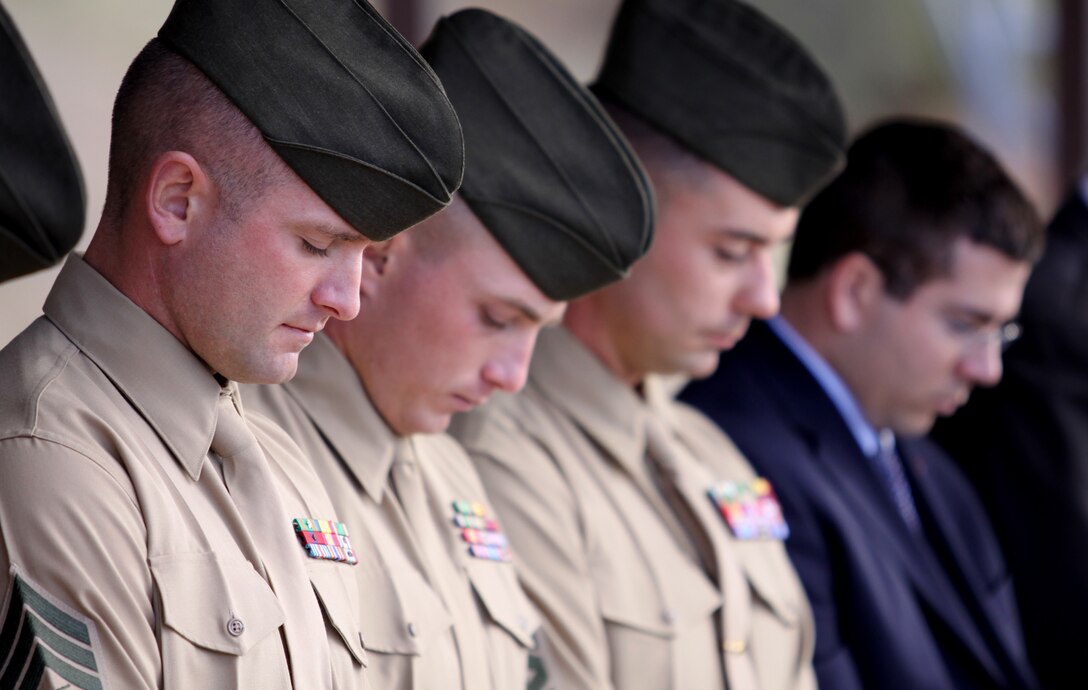 Sgt. Josh W. Huskey, scout sniper instructor and team member, School of Infantry West, Marine Corps Base Camp Pendleton, bows his head alongside fellow team members during the invocation at a Marine Corps Combat Training graduation where local government officials recognized the instructors and the two sniper teams with a Congressional Recognition Award at Camp Pendleton, Dec. 8, for recent sniper competition victories.