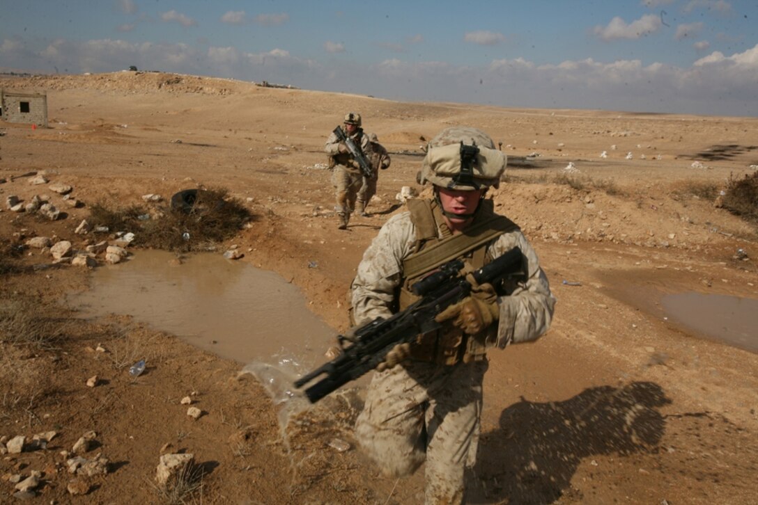 Lance Cpl. David M. Shelton, a rifleman with Company F, Battalion Landing Team 2/4 , 11th Marine Expeditionary Unit, from Warren, Mich., and Lance Cpl. Seth T. Lima, a squad automatic weapon gunner from Safety Harbor, Fla., run from one concealed position to another during live-fire and maneuver training here Dec. 8.