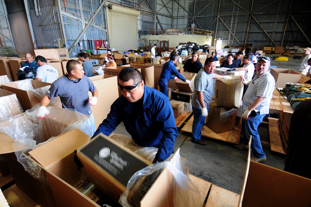 ANDERSEN AIR FORCE BASE, Guam - DZSP-21 volunteers fill a box with goods during the Operation Christmas Drop pack here Nov. 21. More than 20 volunteers from DZSP-21 donated their time to pack more than 25 boxes. Operation Christmas Drop is a non-profit organization powered by volunteers from Andersen Air Force Base and the local Guam community. Each year, the two join forces to aid over 30,000 islanders in Chuuk, Palau, Yap, Marshall Islands and Commonwealth of the Northern Mariana Islands. (U.S. Air Force photo by Airman 1st Class Courtney Witt)