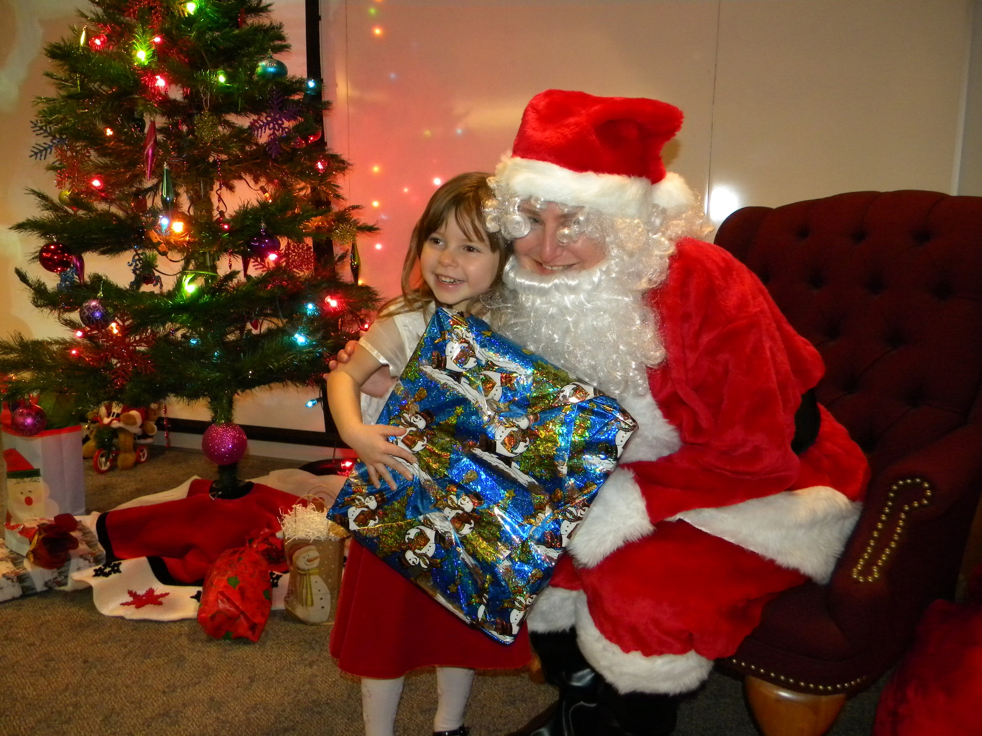 Rachel Williams, daughter of Col. Ben Williams, 713th Combat Operations Squadron Commander, smiles as she accepts her gift from Santa at the 713th Combat Operations Squadron’s holiday party, Dec 6, 2009.  Festivities included a luncheon, children’s activities, and a gift exchange.  The 713th COS is part of the 940th Wing, Beale Air Force Base, Calif. (U.S. Air Force photo/Tech. Sgt. Kenneth McCann)