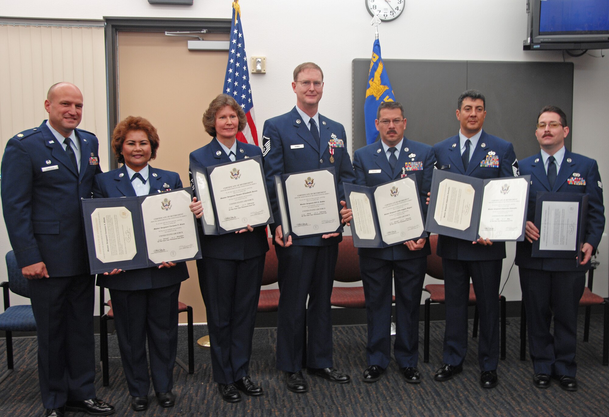 TRAVIS AIR FORCE BASE, Calif. -- Six retirees from the 349th Air Mobility Wing's 45th Aerial Port Squadron here proudly display their retirement certificates following a Dec. 5 ceremony. Pictured from the left are Squadron Commander, Maj. Cary Simpson, officiating; Master Sgts. Corazon Riate, Susan Boren, Bill Hobbs, John Magno and Alejandro Zamudio, and Senior Amn. Roy Baldwin. (U.S. Air Force photo/Senior Master Sgt. Ellen Hatfield)