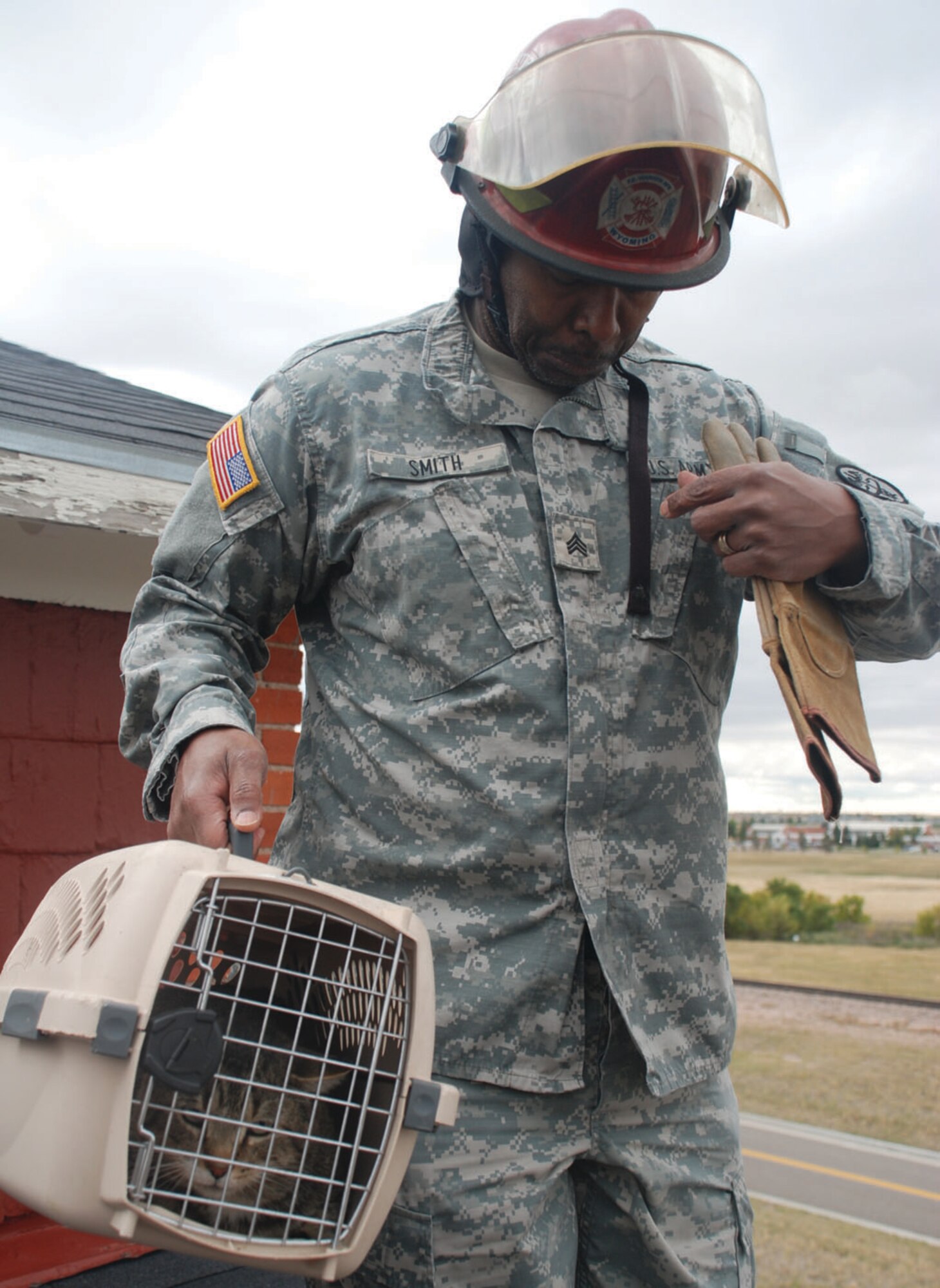 After securing Tiger, Sergeant Smith prepares his helmet and gloves for the descent off of the thrift-shop roof.