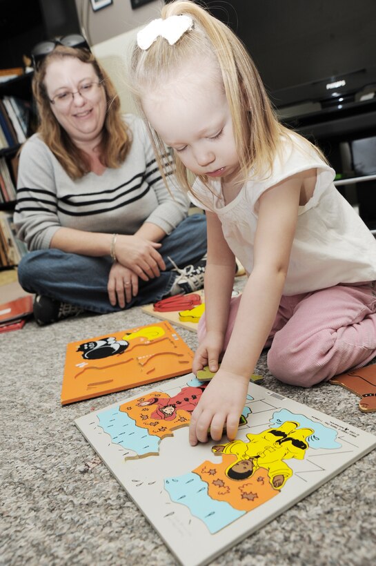 McConnell family member Savannah Holmes plays with a puzzle Nov. 25, 2009, while Stephanie Shellenbarger observes her motor skills at McConnell Air Force Base, Kan. The Parents as Teachers Heroes at Home parent educator program offers servicemembers, military spouses and expecting mothers family support and education for their children before they enter kindergarten. Ms. Shellenbarger is a PAT-HAH educator. (U.S. Air Force photo/Tech. Sgt. Chyrece Campbell)

