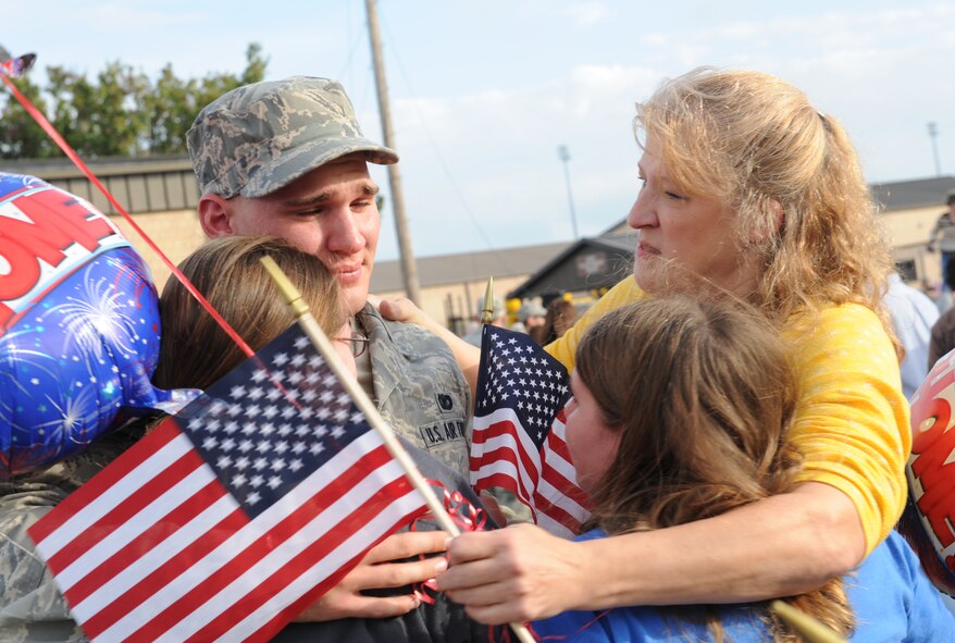 MOODY AIR FORCE BASE, Ga. -- Airman 1st Class James Leach, 822nd Security Forces Squadron member, hugs his mother Rebecca and sisters Jillian and Samantha, after returning home from a deployment to Iraq, here Dec. 8. The 822nd SFS was deployed to Camp Bucca, Iraq, and during the deployment, the squadron executed joint expeditionary taskings and performed outside-the-wire security operations and convoy escort. (U.S. Air Force photo by Airman 1st Class Benjamin Wiseman)