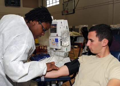 Joelle Parlor does a vein evaluation before taking blood from 2nd Lt. Lyndon Bartlett at the Fitness and Sports Center here Dec. 9. The Red Cross has a monthly goal of drawing 2,000 pints from various donors. Ms. Parlor is a collection specialist with the American Red Cross Charleston Service Center and Lieutenant Bartlett is the officer in charge of plans with the 437th Communications Squadron. (U.S. Air Force photo/Senior Airman Katie Gieratz)(RELEASED)
