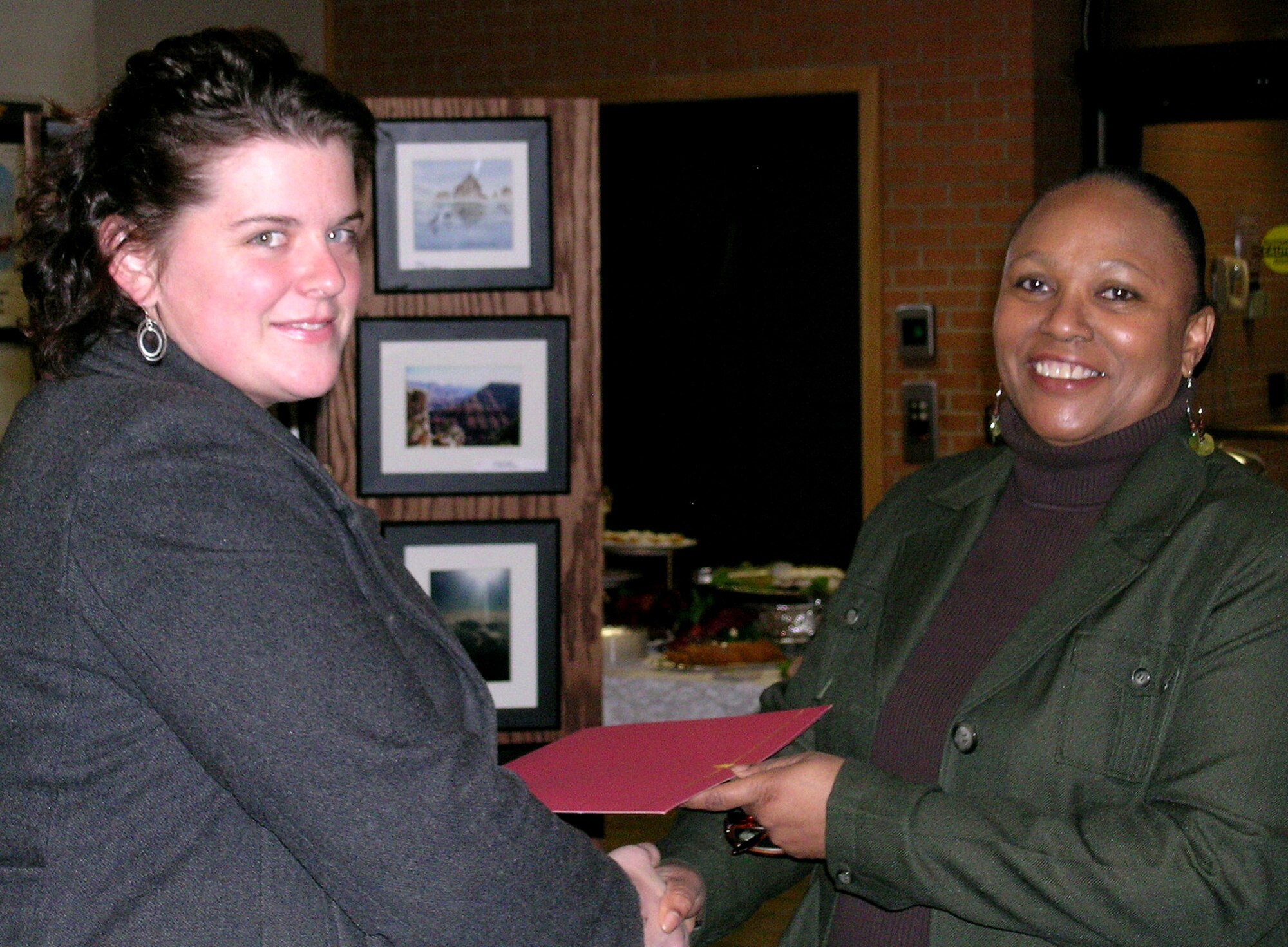 Sarah Markowski, left, one of 12 artists and craftsmen who entered this year’s Artist Craftsman Gallery Showcase at Vance, receives a certificate of creative excellence from Diane McCurdy, the 71st Force Support Squadron director, during a reception Dec. 8 in Bldg. 500. (Photo by Elaine Johns)