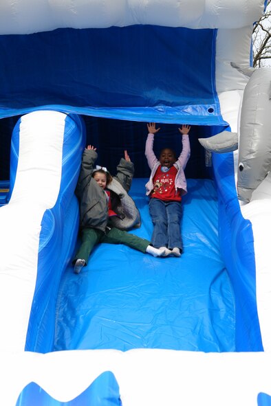 The inflatable slide, part of the activities at the Children’s Christmas Party Dec. 6 at the Arnold Lakeside Center, captured the attention of these two girls. (Photo by Andrea Stephens)