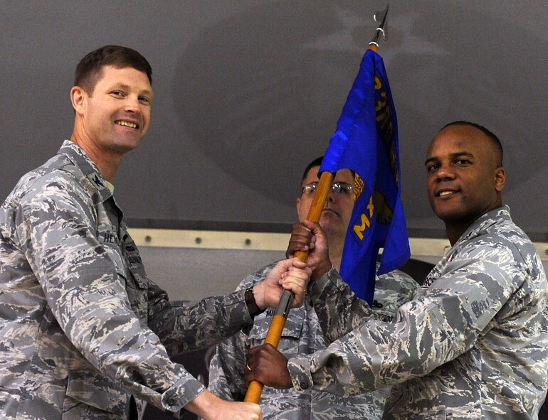 MOODY AIR FORCE BASE, Ga. -- Col. Gary Henderson, 23rd Wing commander, passes the guide on to Col. Neal Robinson, 23rd Maintenance Group incoming commander, during the 23rd MXG assumption of command ceremony here Dec. 7. Colonel Robinson is former Chief of the Command, control, intelligence, surveillance, reconnaissance division, for Air Combat Command, Langley Air Force Base, Va. (U.S. Air Force photo by Airman 1st Class Joshua Green)