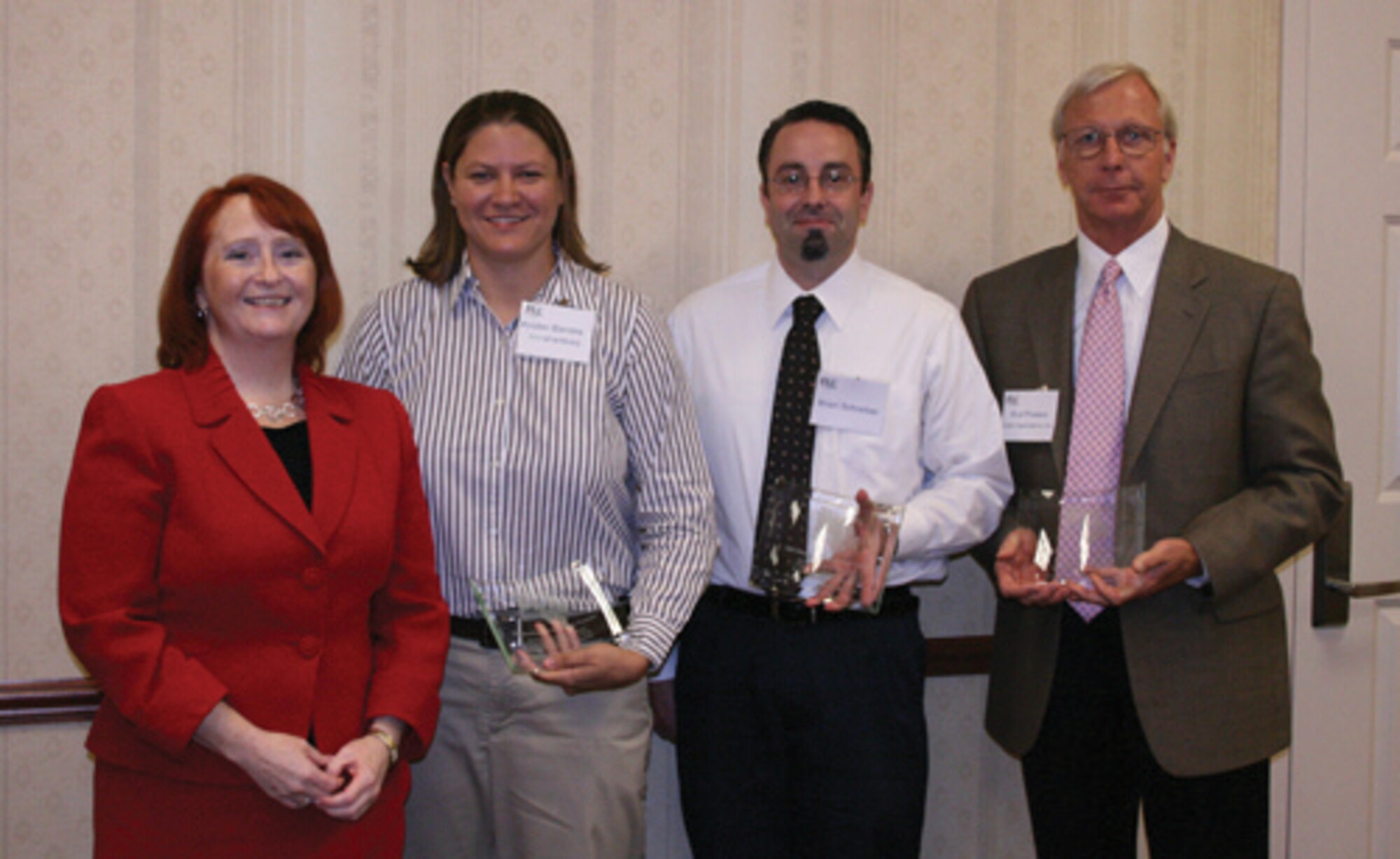 Kristen Schario (pictured far left), regional coordinator for the Federal Laboratory Consortium Midwest Region, presented an FLC Excellence in Technology Transfer award to AFRL's Live-Virtual-Constructive technology team.  Pictured left to right are Kristen Barrera, LVC program manager, and AFRL collaborators Brian Schreiber (LUMIR Research, Inc.) and Rod Powers (Cubic Applications, Inc.) (Photo by Amanda Snyder, FLC)