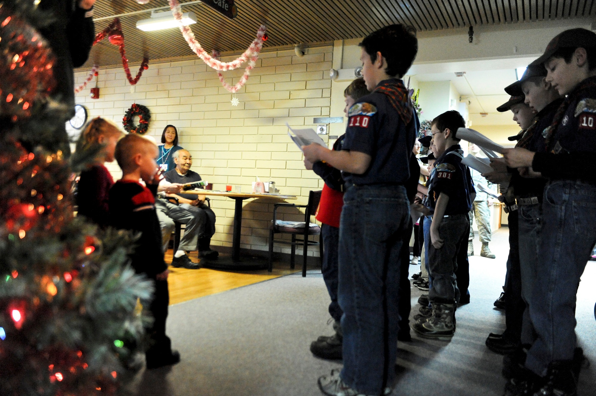 PIONEER VETERANS HOME, Alaska – Members from Cub Scout Pack 110 sing Christmas carols to residents of the Pioneer Veterans Home Dec. 5.  The pack sang Christmas carols as part of a community service project.  (U.S. Air Force photo/Airman 1st Class Christopher Gross)