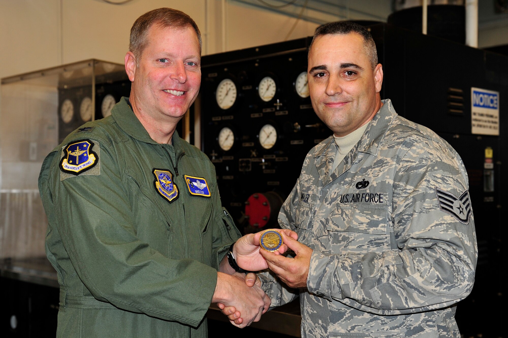 Col. Michael Zick, 19th Airlift Wing vice commander, presents Staff Sgt. Brian Moler, 189th Maintenance Group aircraft fuel systems craftsman, a 19th AW commander’s coin Dec. 8 for being selected the Combat Airlifter of the Week. As team leader, Sergeant Moler guided completion of more than 40 fuels system repairs, which contributed to wing's 98 percent fuels system reliability rate with zero repeat write-ups. (U.S. Air Force photo by Airman 1st Class Lausanne Pacheco)