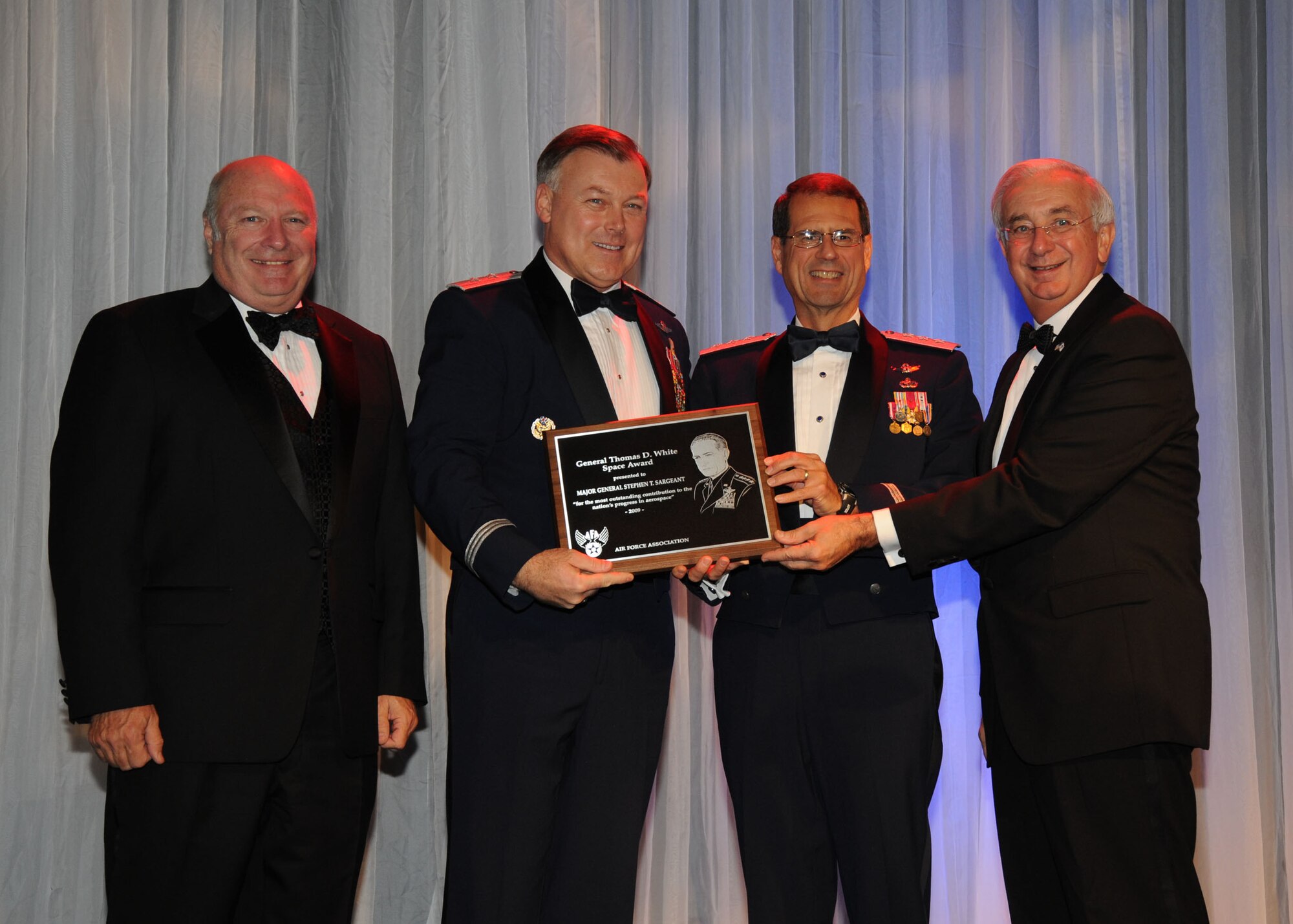 (Left to right) Retired Maj. Gen. Thomas Taverney, the Air Force Association's General Schriever Los Angeles Chapter President presents the 2009 General Thomas D. White U.S. Air Force Space Trophy to Maj. Gen. Stephen T. Sargeant, Air Force Operational Test and Evaluation Center Commander, with the assistance of Gen. John Sheridan, Space and Missile System Center Commander, and Mr. Joseph Sutter, Air Force Association Board Chairman. General Sargeant received the trophy at the annual Air Force Ball held Nov. 20 in Beverly Hills, Calif. (Photo courtesy of the Air Force Association).