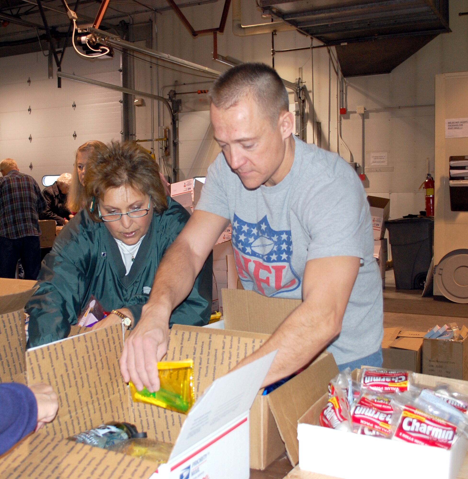 Dimmer Kjelsrud and Master Sgt. B.J. Harley make sure the items going into the care packages are packed the same way. This is the 11th year Operation Happy Holidays has shipped care packages to deployed Montana servicemembers and Ms. Kjelsrud, the marketing director for 1st Liberty Federal Credit Union, has been involved in all of them. This is the first year participating for Sergeant Harley, who is a member of the 16th Munitions Squadron. (U.S. Air Force photo/Valerie Mullett)