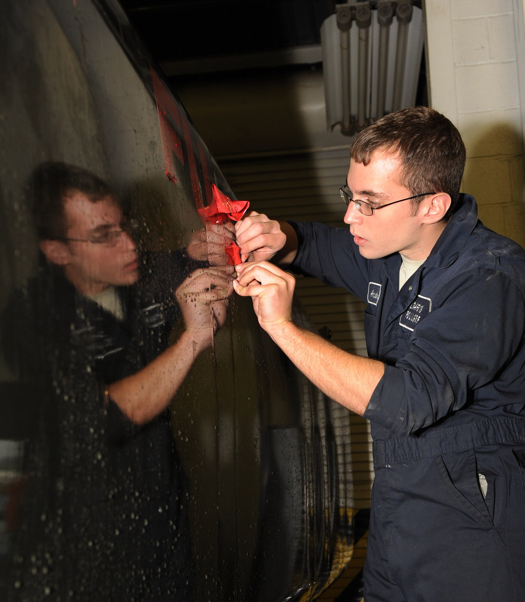Senior Airman Alex Andreassi, 19th Logistics Readiness Squadron refueling maintenance journeyman, removes stencils from an R-11 refueling truck Dec. 2.  The 19th Logistics Readiness Squadron fuels flight is changing from Jet Propulsion 8 (JP-8) to Jet A fuel to streamline logistics by eliminating the need for specialty fuel and to reduce operating costs.  (U.S. Air Force photo by Staff Sgt. Chad Chisholm)