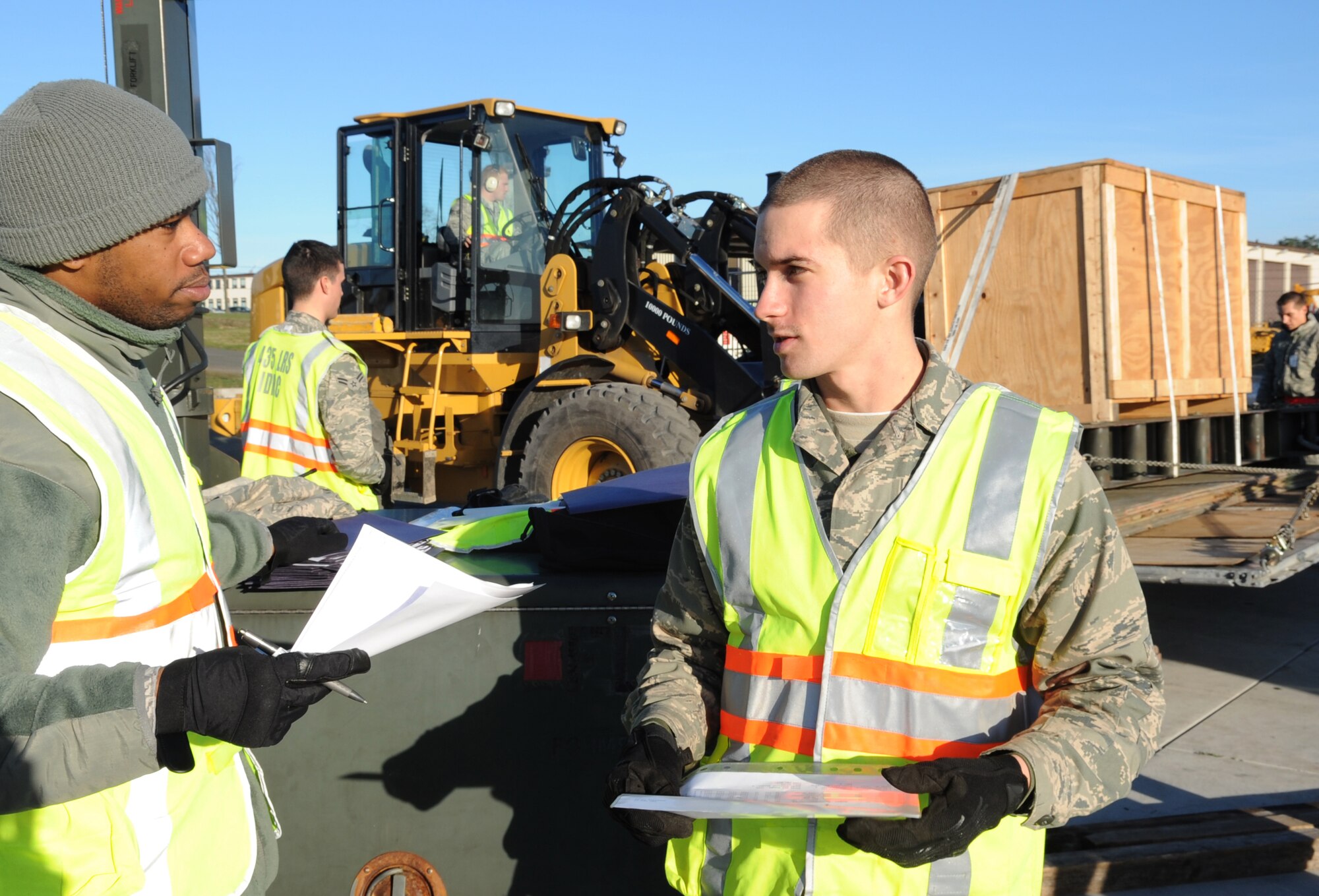 U.S. Air Force Staff Sgt. Lew Johnson, flight services journeyman and Airman Joshua Mullennix, aerial delivery apprentice, both from the 86th Logistics Readiness Squadron, go over packing forms for the cargo during a base exercise, Ramstein Air Base, Germany Dec. 9, 2009.  This exercise is part of the Phase I of the operation readiness exercises to evaluate mission readiness in preparation for real world deployments. (U.S. Air Force photo by Airman 1st Class Caleb Pierce)   