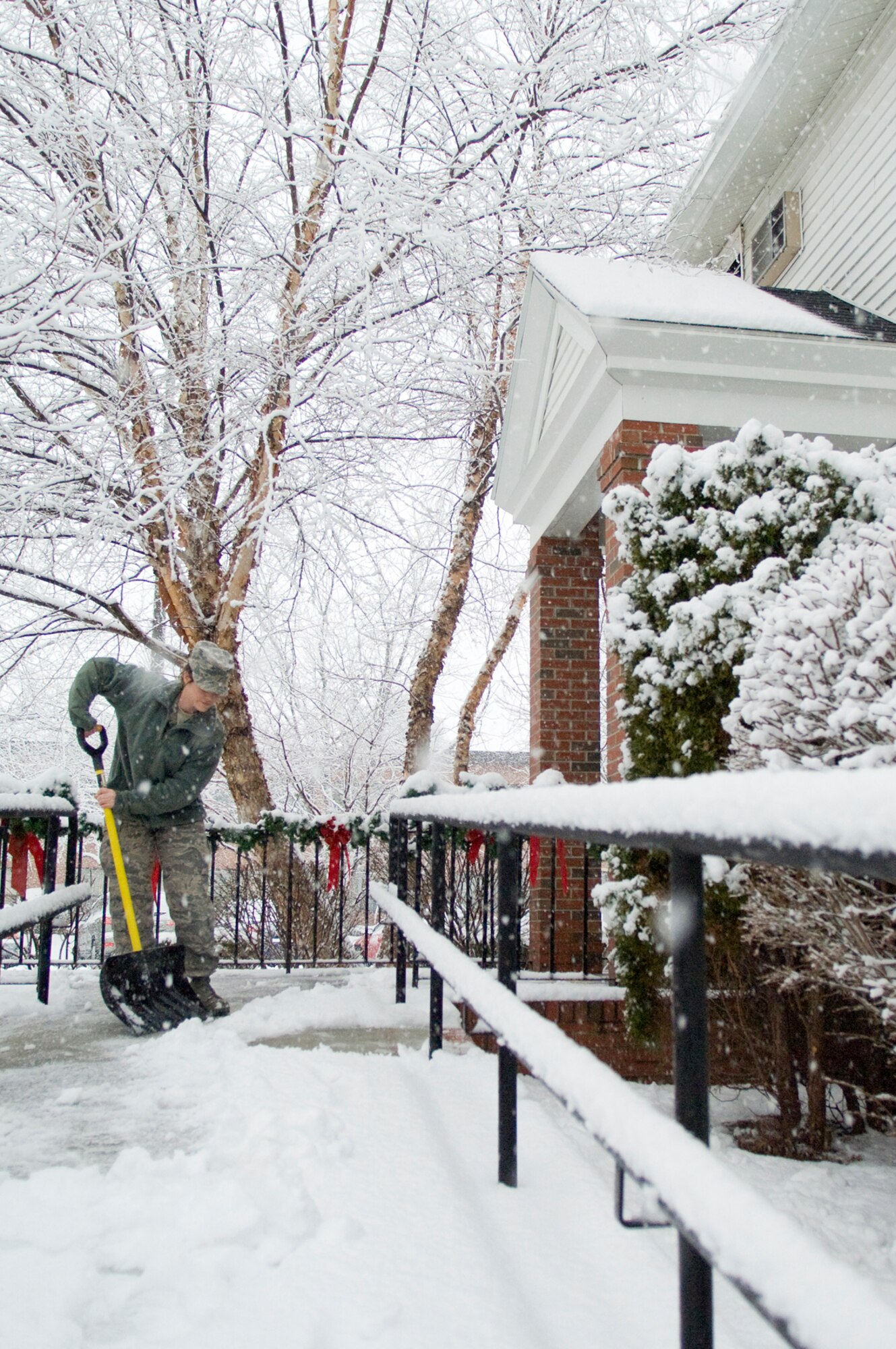 HANSCOM AIR FORCE BASE, Mass. -- Senior Airman Jessica Jacques, Base Chapel chaplain assistant, removes snow from the chapel steps during a snow storm Dec. 9.  (U.S. Air Force photo by Mark Wyatt)  