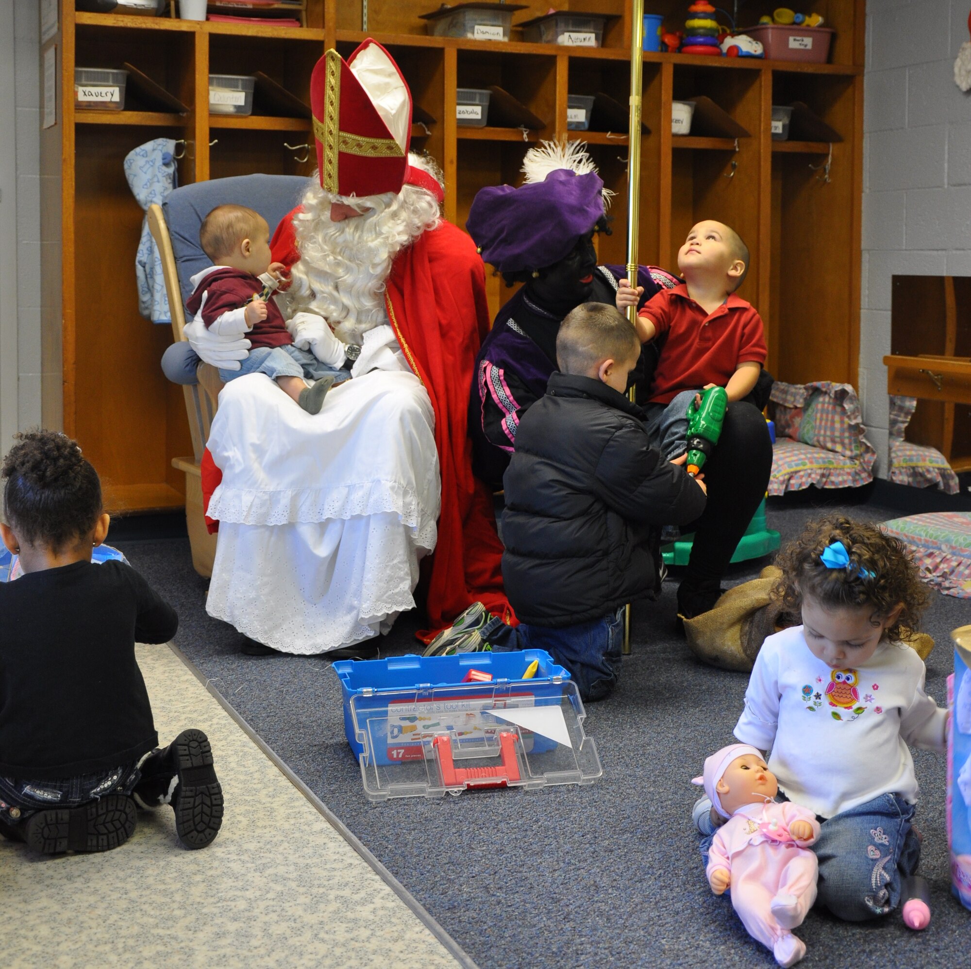 Sinterklaas (left) and Black Peter hand presents to children Dec.4 at the Ben Donnell Day Care Center in Wichita Falls, Texas. The Dutch community at Sheppard makes an annual trek to the day care center to give presents to children. Sinterklaas, the equivalent of Santa Claus, is the gift-giver to the children of The Netherlands. Black Peter, Sinterklaas' assistant, who is covered with soot from sliding down the chimney, helps Sinterklaas hand out the gifts. (U.S. Air Force photo/Airman 1st Class Adawn Kelsey)


