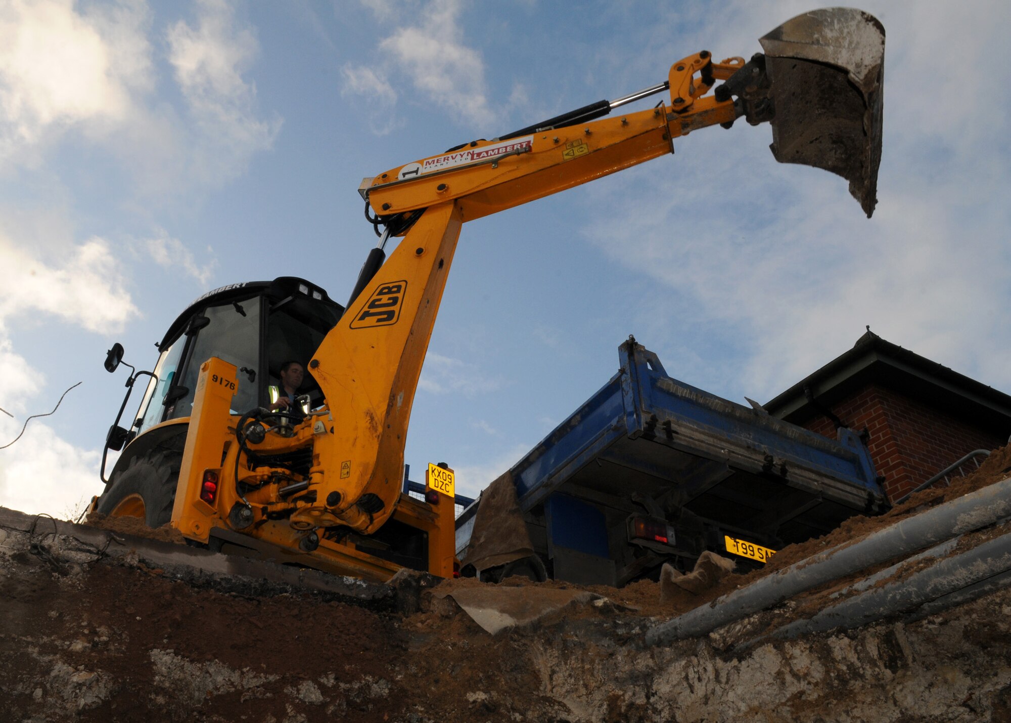 RAF MILDENHALL, England – Paul Wiseman, a local contractor, uses a backhoe to uncover and replace a water valve next to Building 445 Dec. 5. This is the 10th valve replacement completed this year to provide safe drinking water to Team Mildenhall. (U.S. Air Force photo/ Staff Sgt. Jerry Fleshman)