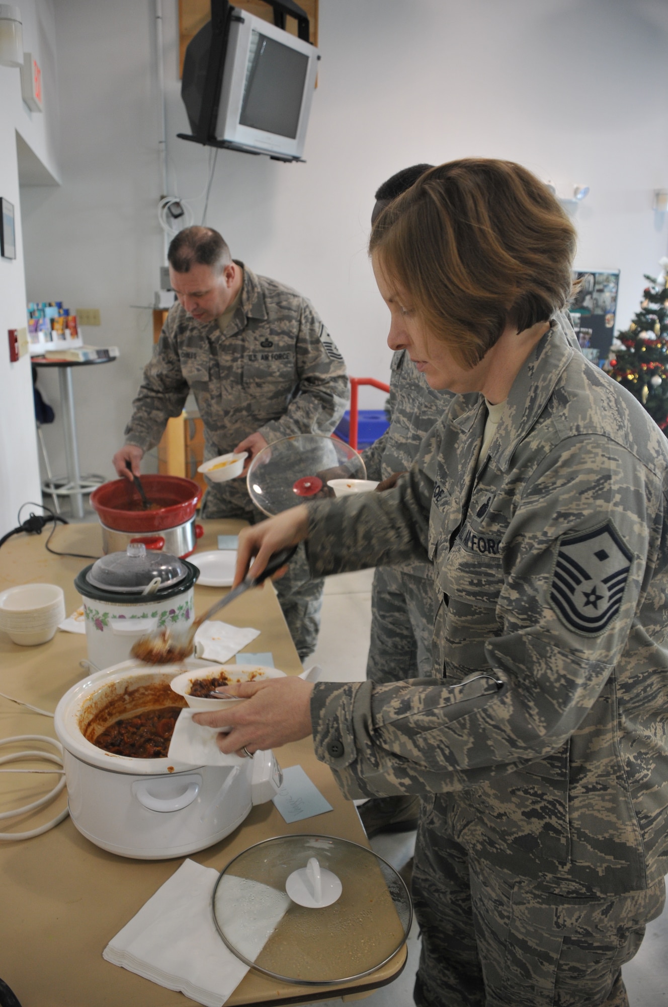Master Sgt. Susan Roe, McGuire Air Force Sergeants Association president,  and Master Sgt. Alan Chiles, 87th Operations Support Squadron, load up on some chili during the Chili Cook-off contest held at the Airmen's Firehouse, Dec. 8. (U.S. Air force Photo/ Pascual Flores)