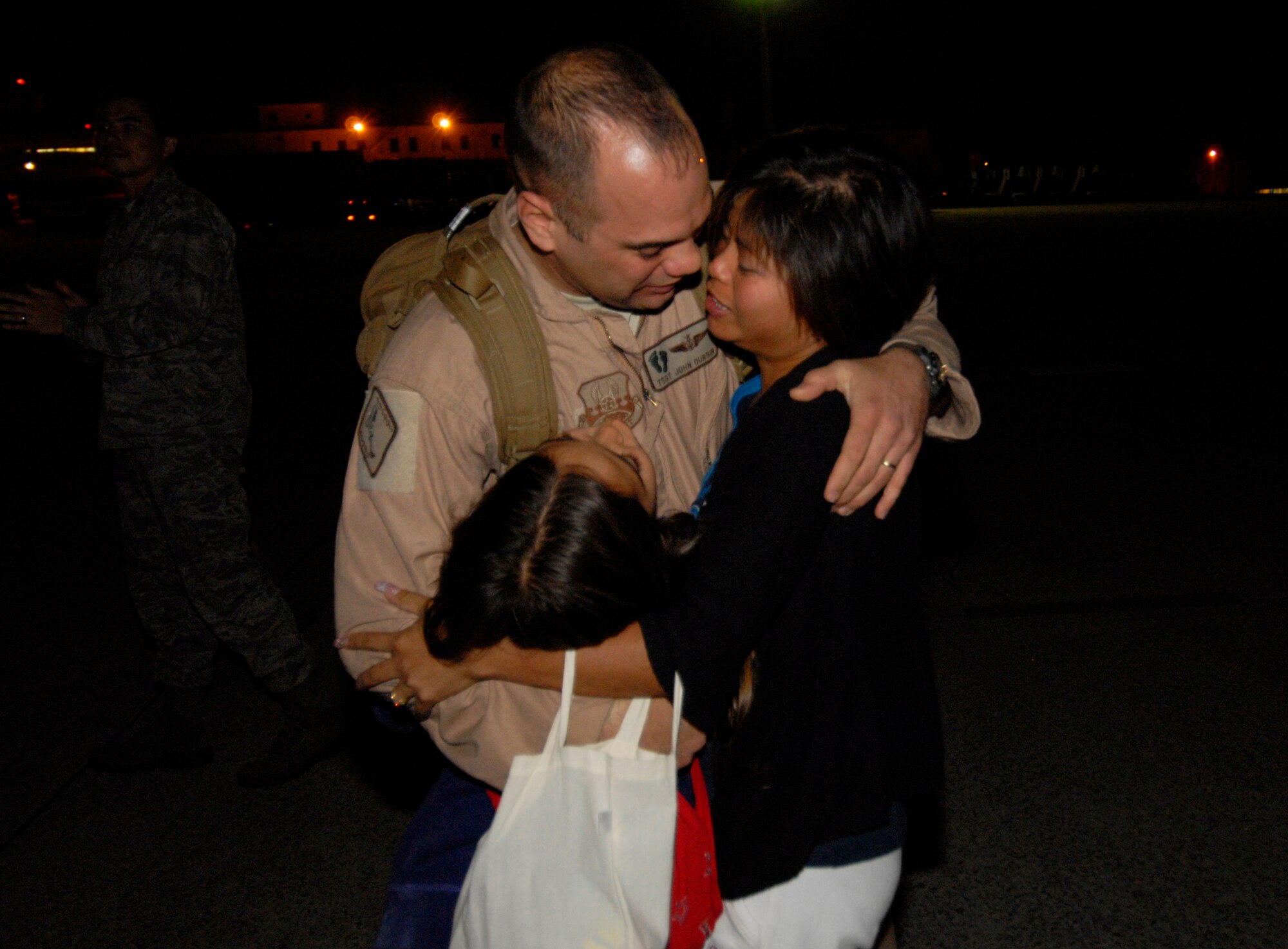 Tech. Sgt. John Durbin, a 33rd Rescue Squadron flight engineer, embraces his family upon his return to Kadena Dec. 8. Dozens of friends and family members welcomed more than 60 Airmen as they returned from a deployment to Afghanistan in support of Operation Enduring Freedom. (U.S. Air Force/Airman 1st Class Chad Warren)