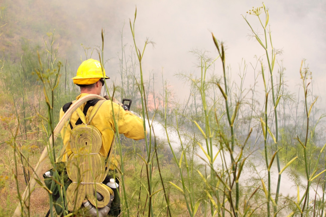 Graham Koonce, a nozzleman with Cleveland National Forest Fire Department, responds to a fire during Fire School, June 9 at Camp Pendleton. Fire School is a the two-week, live-fire training exercise, and is designed to give crews experience responding to, and extinguishing, wild land fires.