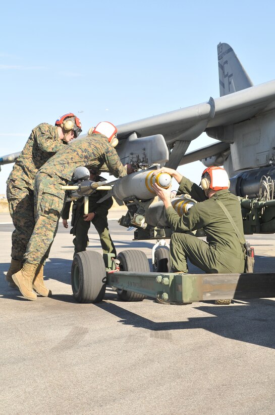 Ordnance technicians with Marine Attack Squadron 211 reload an AV-8B Harrier with Mark 82 bombs as part of a hot reloading exercise at the Yuma Proving Ground Dec. 9, 2009. Hot reloading requires personnel to secure live ordnance onto the aircraft while the aircraft is still running. The reloading was part of Exercise Prairie Fire, which had the Marines working as if they were on the airstrip of a forward operating base. “The purpose of these types of exercises is to prepare Marines for their next deployment,” said Capt. Timothy Hudson, squadron pilot. The squadron is based at the Marine Corps Air Station in Yuma, Ariz.