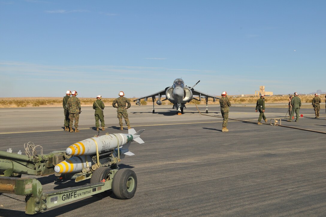 Marines with Marine Attack Squadron 211 gather on the Yuma Proving Ground flight line for a forward operating base simulation on Dec. 9, 2009. The squadron prepared for future deployments by using the airfield to simulate a forward operating base’s airstrip, to reloads live ordnance on the aircraft while it is still running. “We use it to our advantage to teach the Marines how to work as a cohesive unit,” said Capt. Andrew D’Ambrogi, squadron pilot. The squadron is based at the Marine Corps Air Station in Yuma, Ariz.