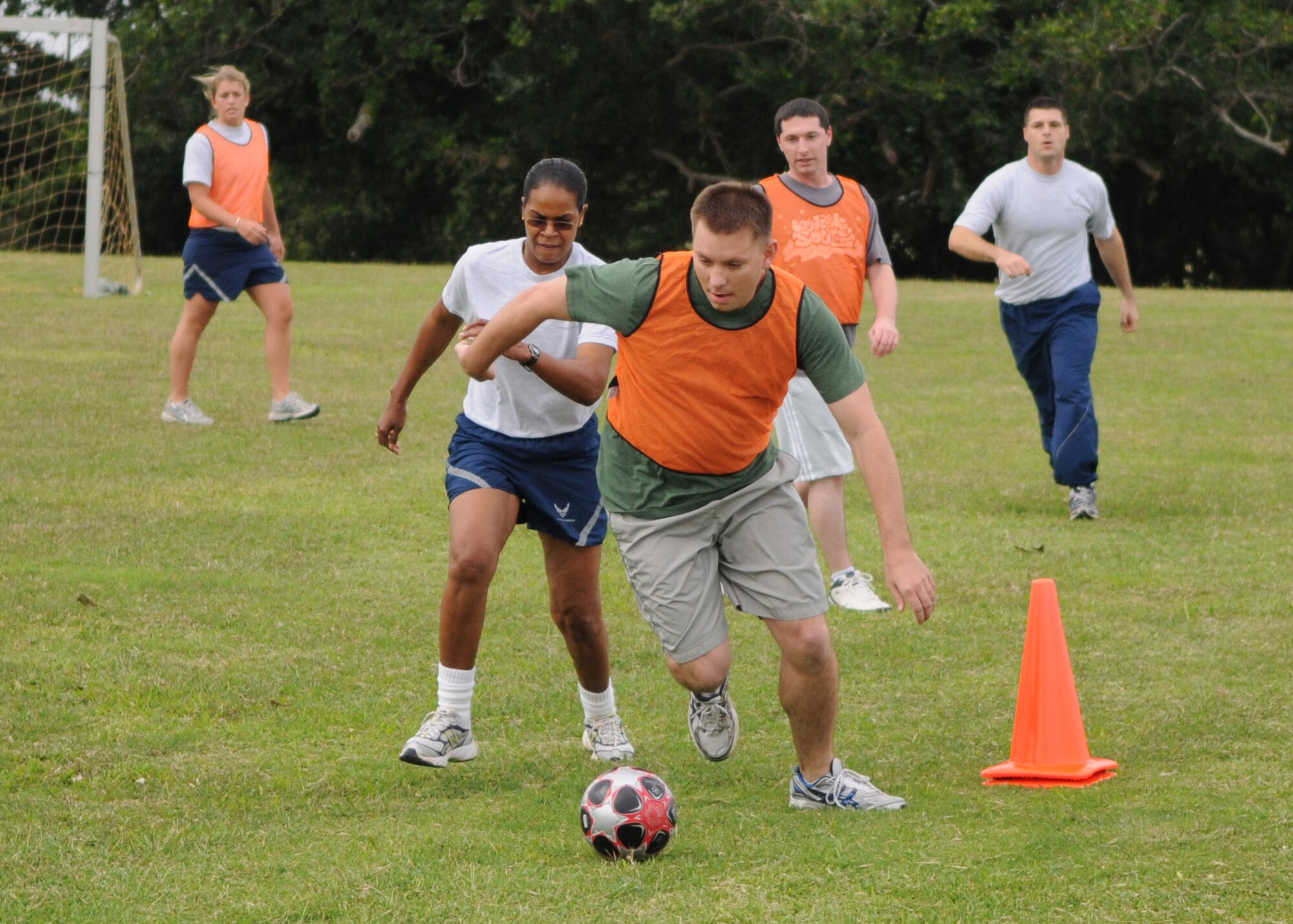 KADENA AIR BASE, Japan -- Nick Johnson, from the 353rd Maintenance Squadron team, runs past the 353rd Operations Support Squadron?s Sophia Walters during a soccer match Nov. 30 as part of the inaugural 353rd Special Operations Group Sports Week Nov. 30 - Dec. 4.  Sports week pitted the units assigned to the group against each other in 10 sporting events ranging from basketball to a modified relay race. The 353rd MXS team won the soccer match. (U.S. Air Force photo by Tech. Sgt. Aaron Cram)