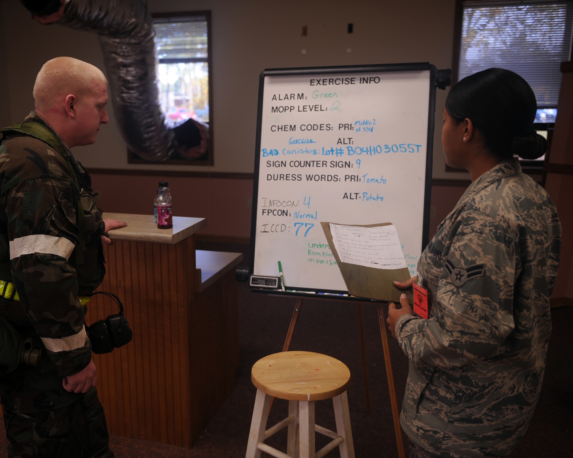 Airman 1st Class Kayla Kyle, 4th Mission Support Group knowledge operations manager, briefs Senior Airman Travis Heller, 336th Aircraft Maintenance Squadron crew chief, of current exercise information at the transition area during the operational readiness exercise on Seymour Johnson Air Force Base, N.C., Dec. 10, 2009. All Airmen are briefed on exercise information when transitioning into Base X. (U.S. Air Force photo/Senior Airman Ciara Wymbs) 