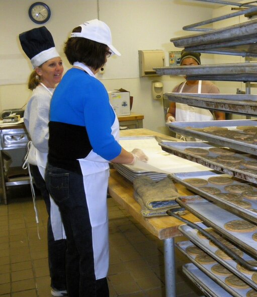 Lt. Col. Lynne Hull, 419th Fighter Wing inspector general, and Master Sgt. Kathalene Hale, 419th FW historian, bake cookies to be delivered to wing personnel during the December UTA. (U.S. Air Force photo/Staff Sgt. Kyle Brasier)