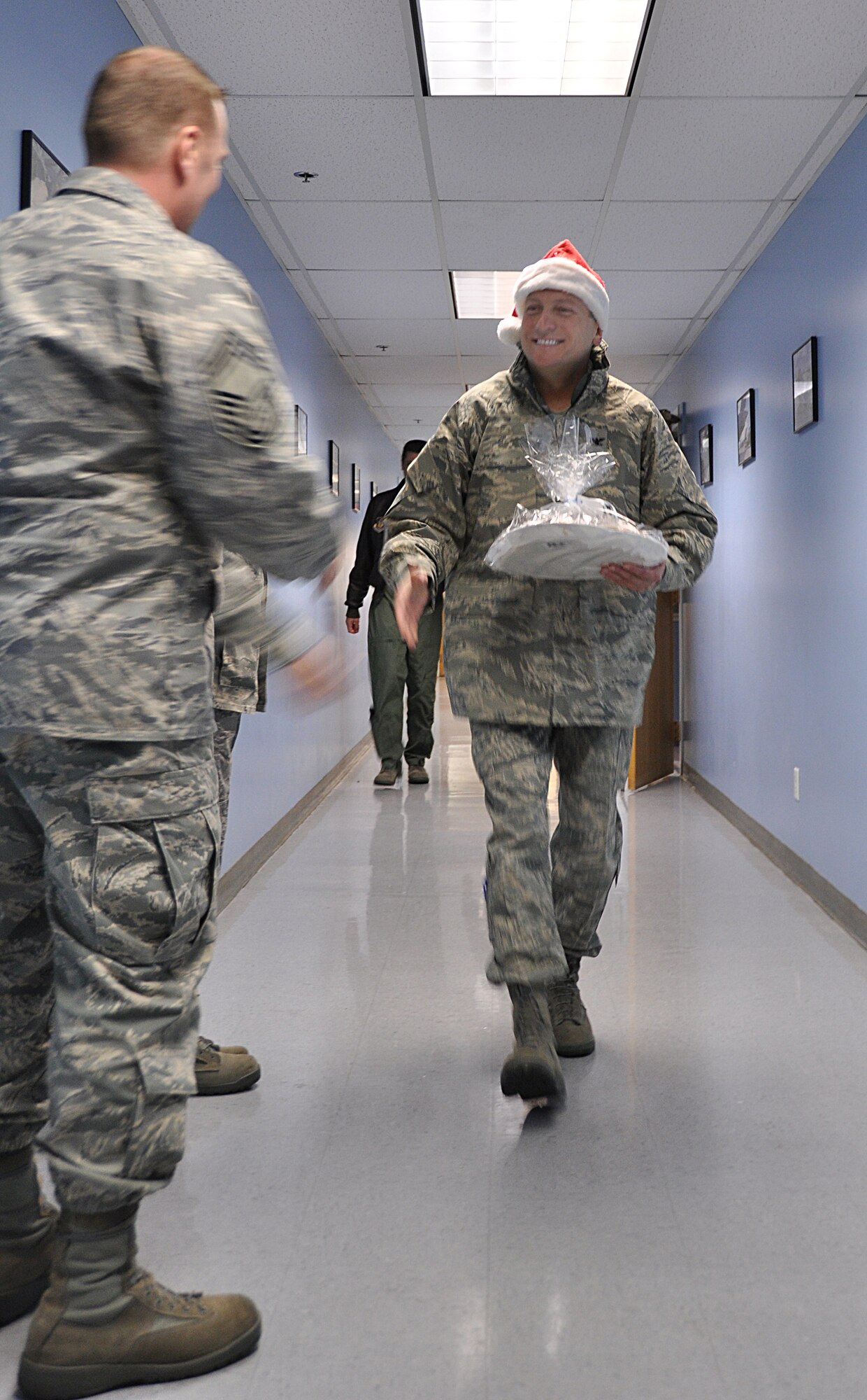 Col. Walter “Buck” Sams, 419th Fighter Wing commander, delivers plates of cookies to members of the 67th Aerial Port Squadron and the 419th Logistics Readiness Squadron during the December UTA. The colonel briefly visited each squadron to extend warm holiday wishes. (U.S. Air Force photo/Staff Sgt. Heather Skinkle)